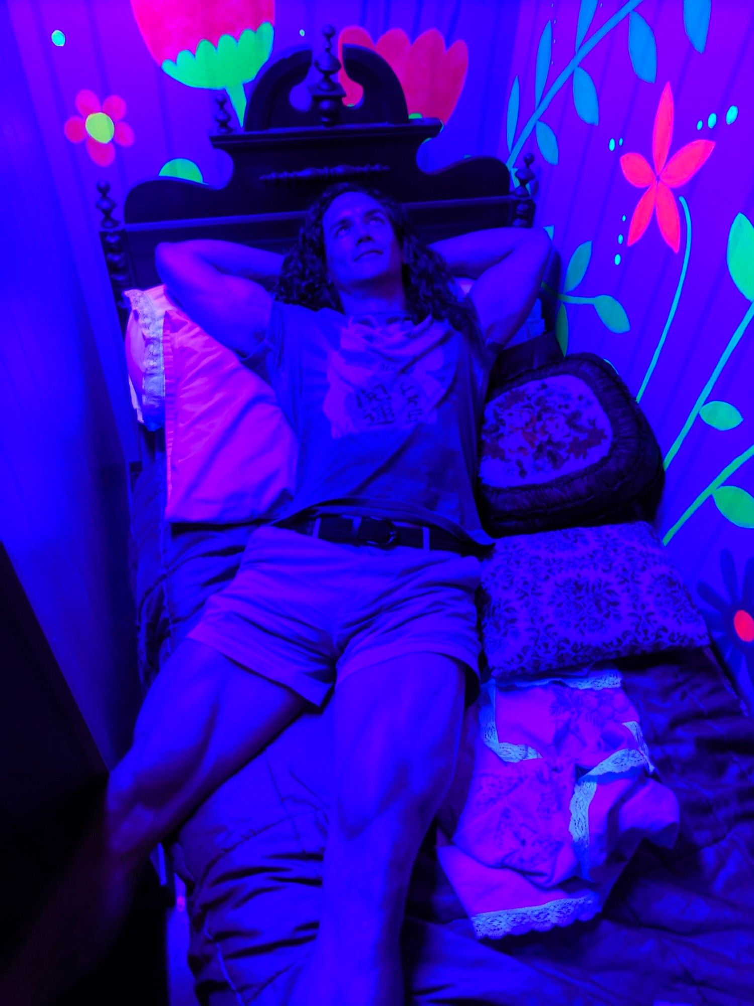 dude with shaggy hair and short shorts lying down in rave lighting. vastus medialis visible