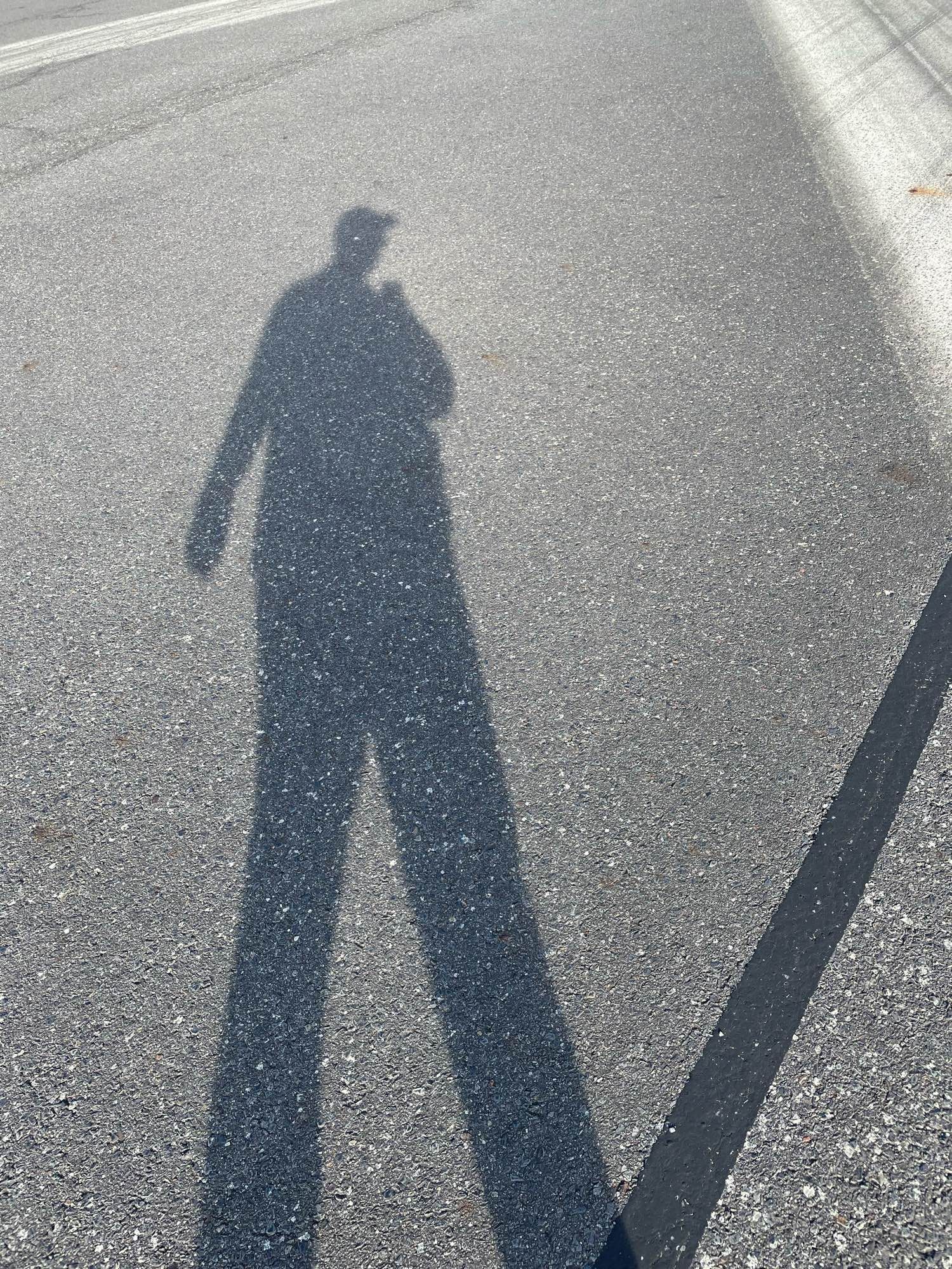 schatten eines mannes auf asphalt