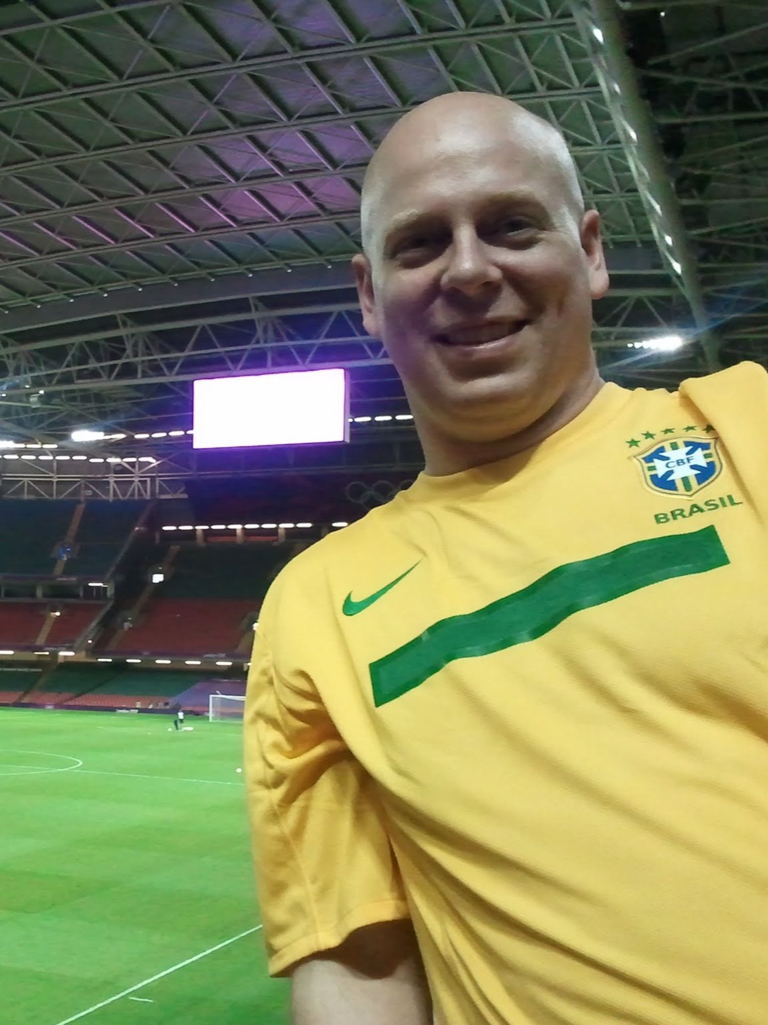 Brian leaning awkwardly into a selfie  wearing the bright yellow and green colors of Brasil before a 2012 Olympic women's football match at Cardiff's Millennium Stadium.