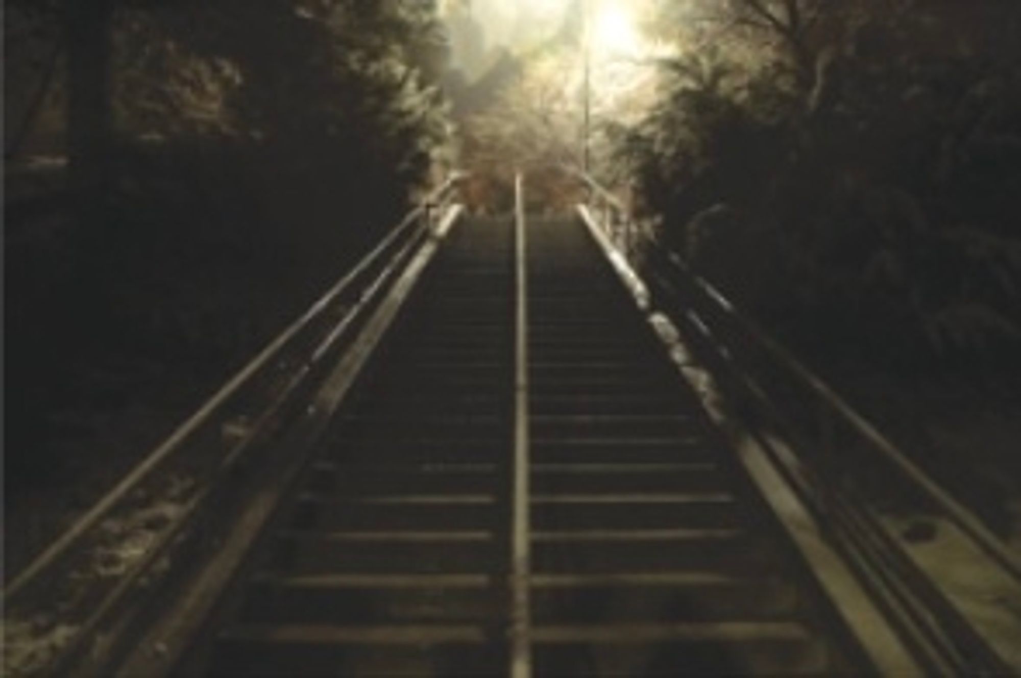 Schlecht beleuchtete Treppe in der Nacht, oben ist eine Straßenlaterne