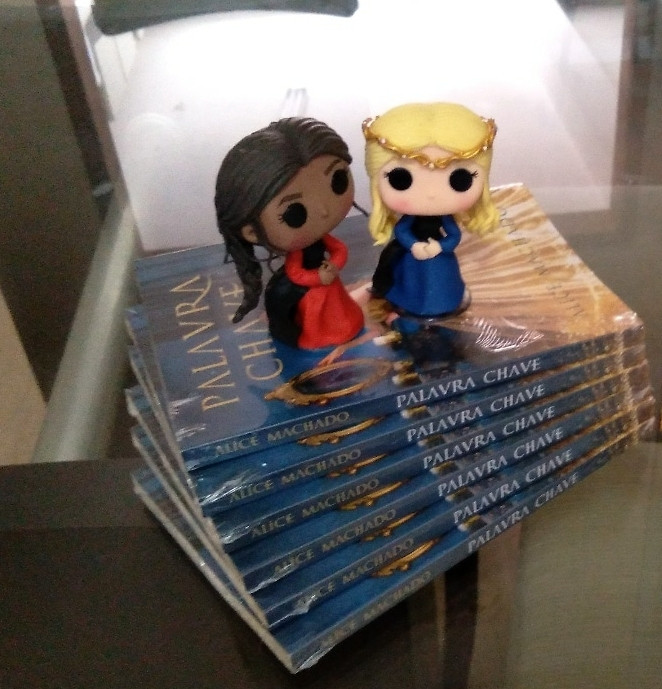 Pilha de livros com dois funkos artesanais em cima 