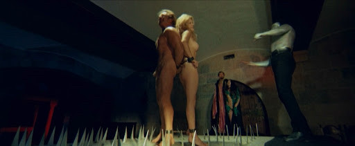A nude couple being flogged by the Frankenstein monster who is wearing nothing but pants and boots 

The Erotic Rites of Frankenstein (1973), Jesús Franco 