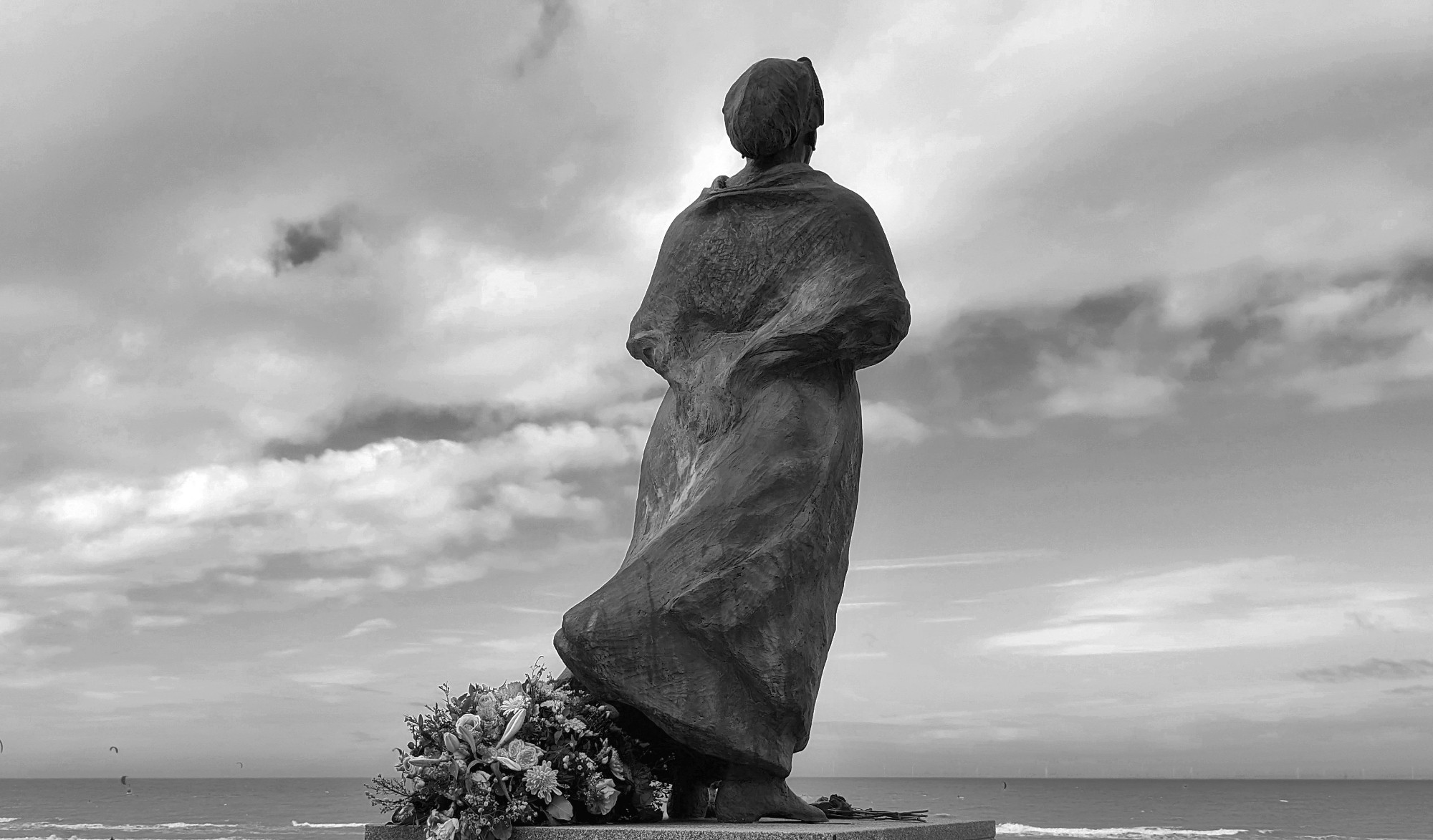 Beeld van wachtende vissersvrouw op Scheveningen. Zwart wit.