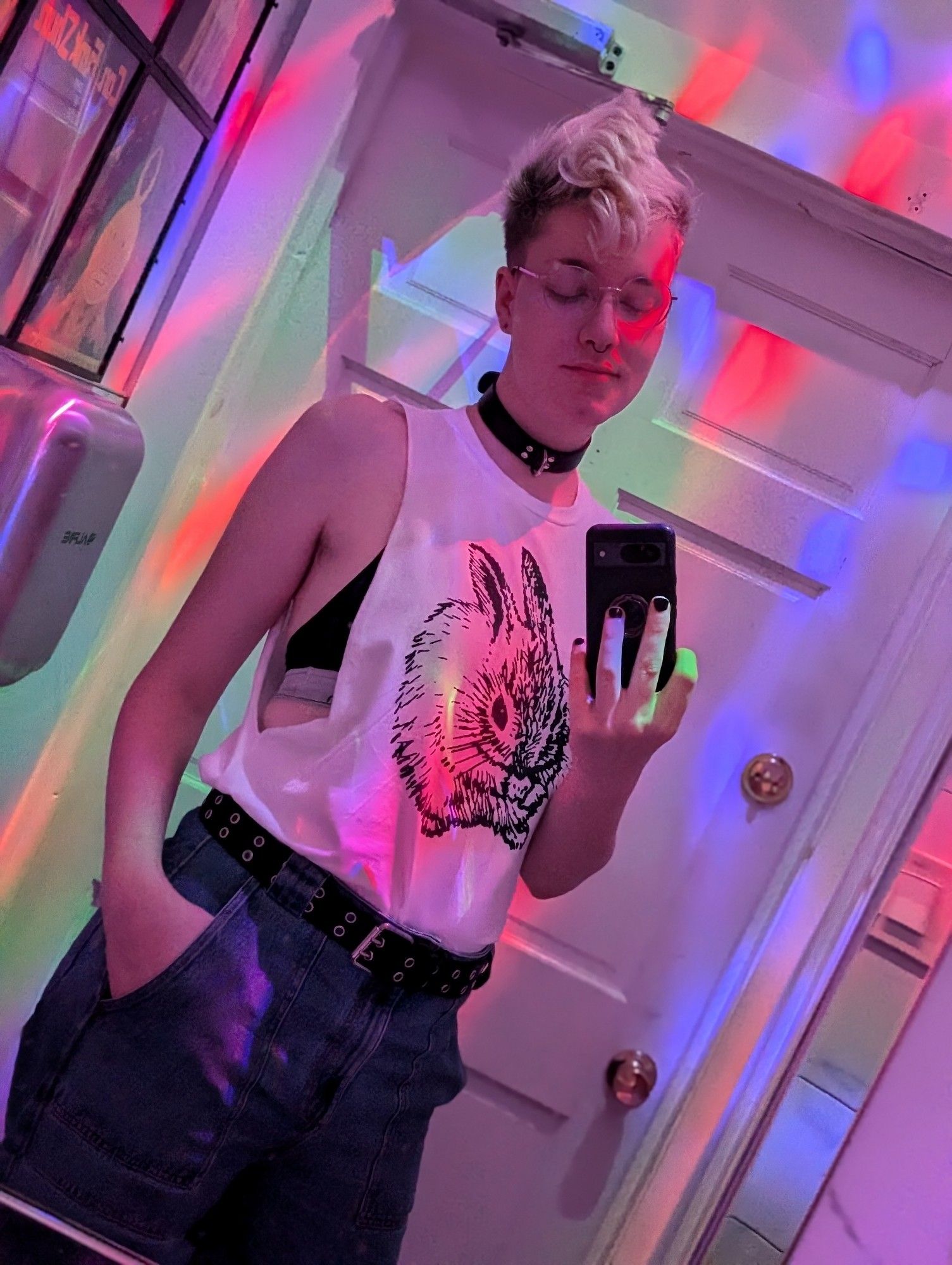 a boy in a bathroom mirror lit by disco lights