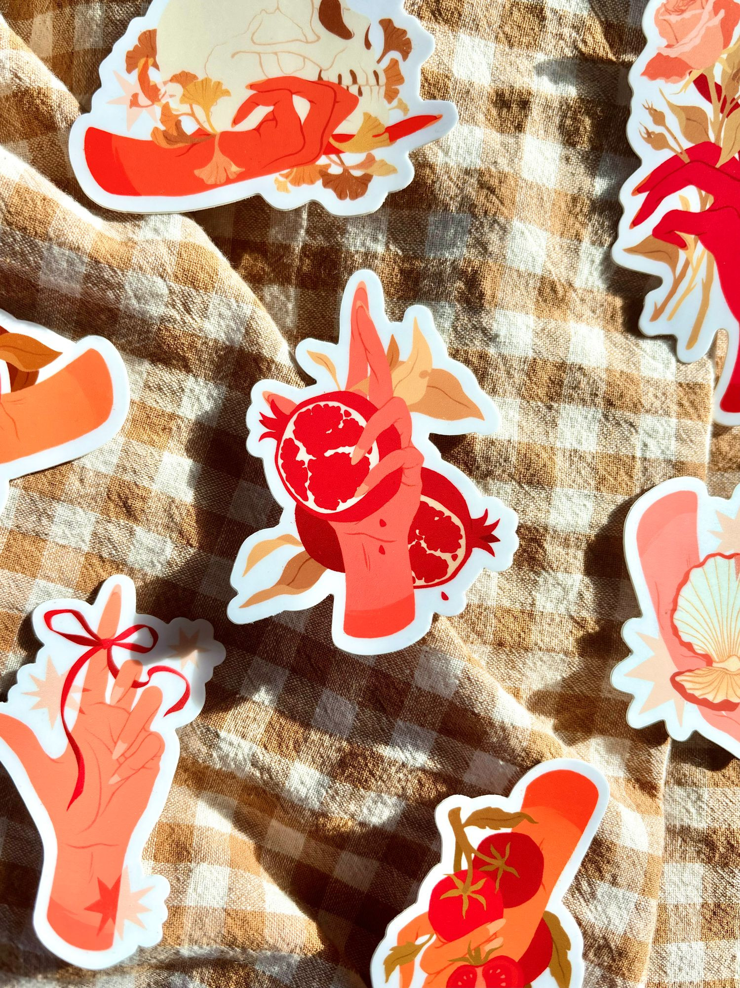 Photo of six autumn stickers designed by Samantha Mash in bright sunlight on a brown and white gingham backdrop