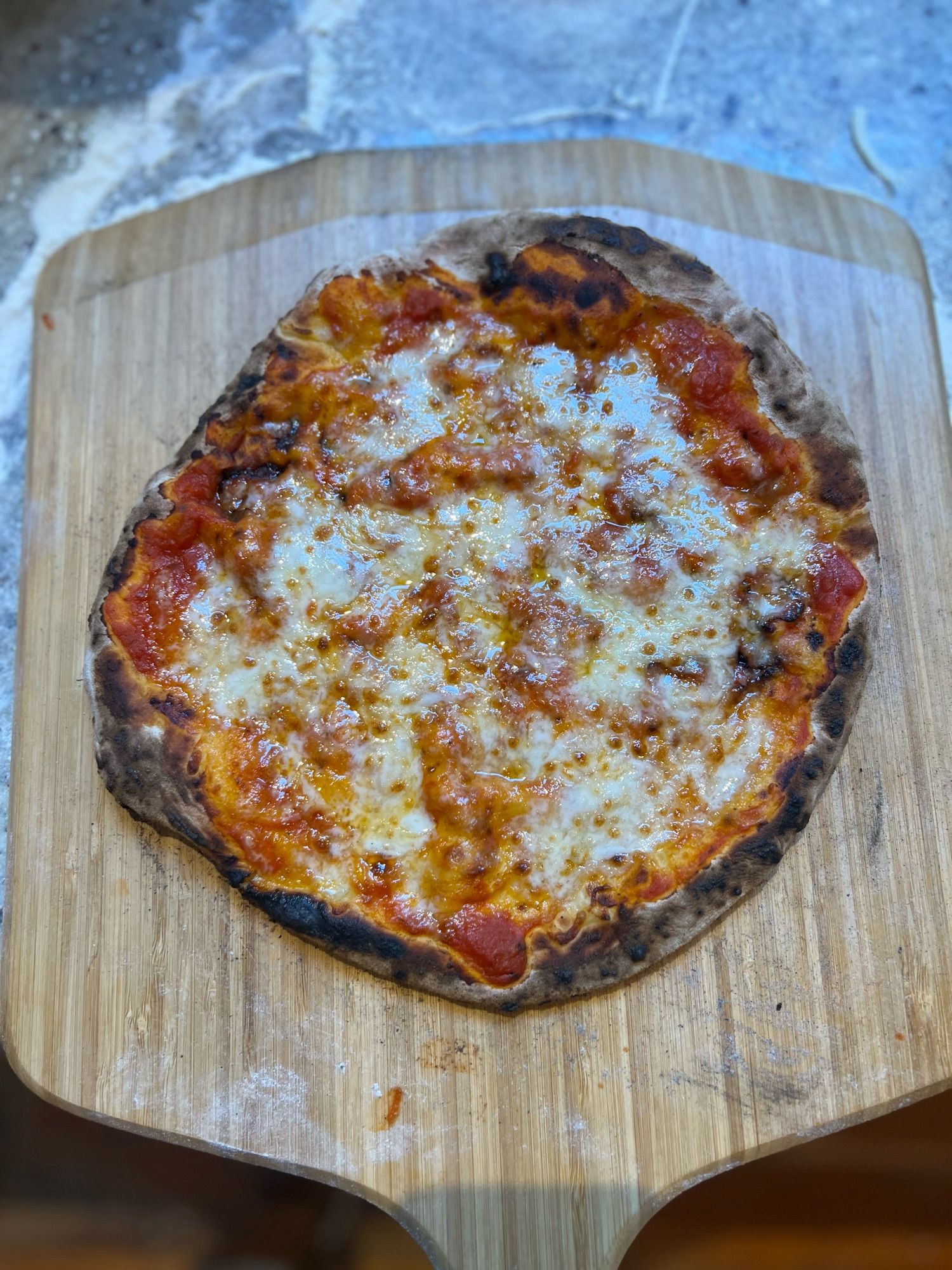 An absolutely perfectly baked pizza pie (cheese) on a wooden board.