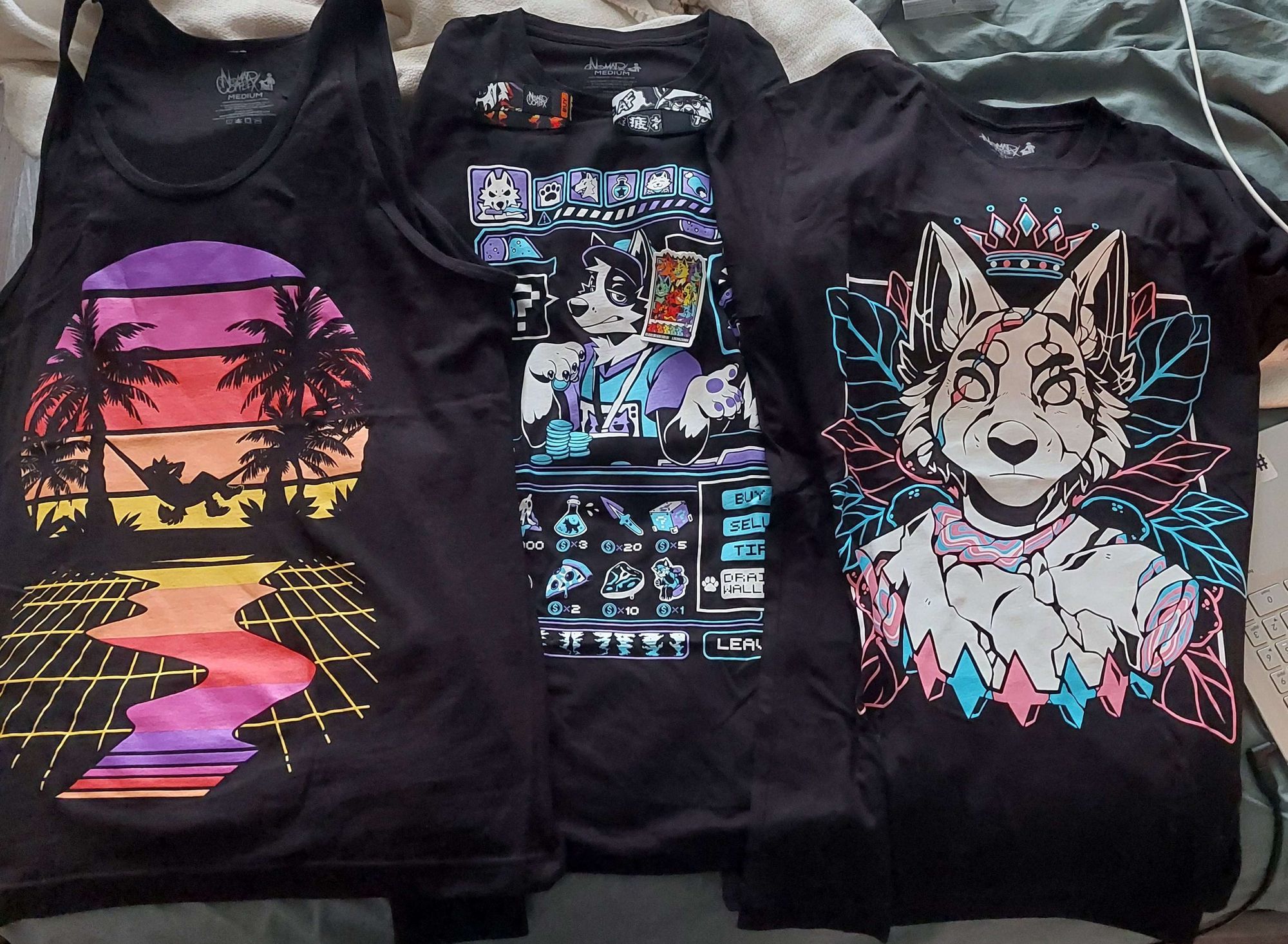 Laid across a full sized bed are three tops, a tank top, a long-sleeve shirt, and a regular tee shirt. All three shirts are products from the furry apparel Nomad Complex.

Tank Top - Vibin' (Sunset)
Long Sleeve - Shopkeeper
T-Shirt - Unbreakable Pride (Trans)

T