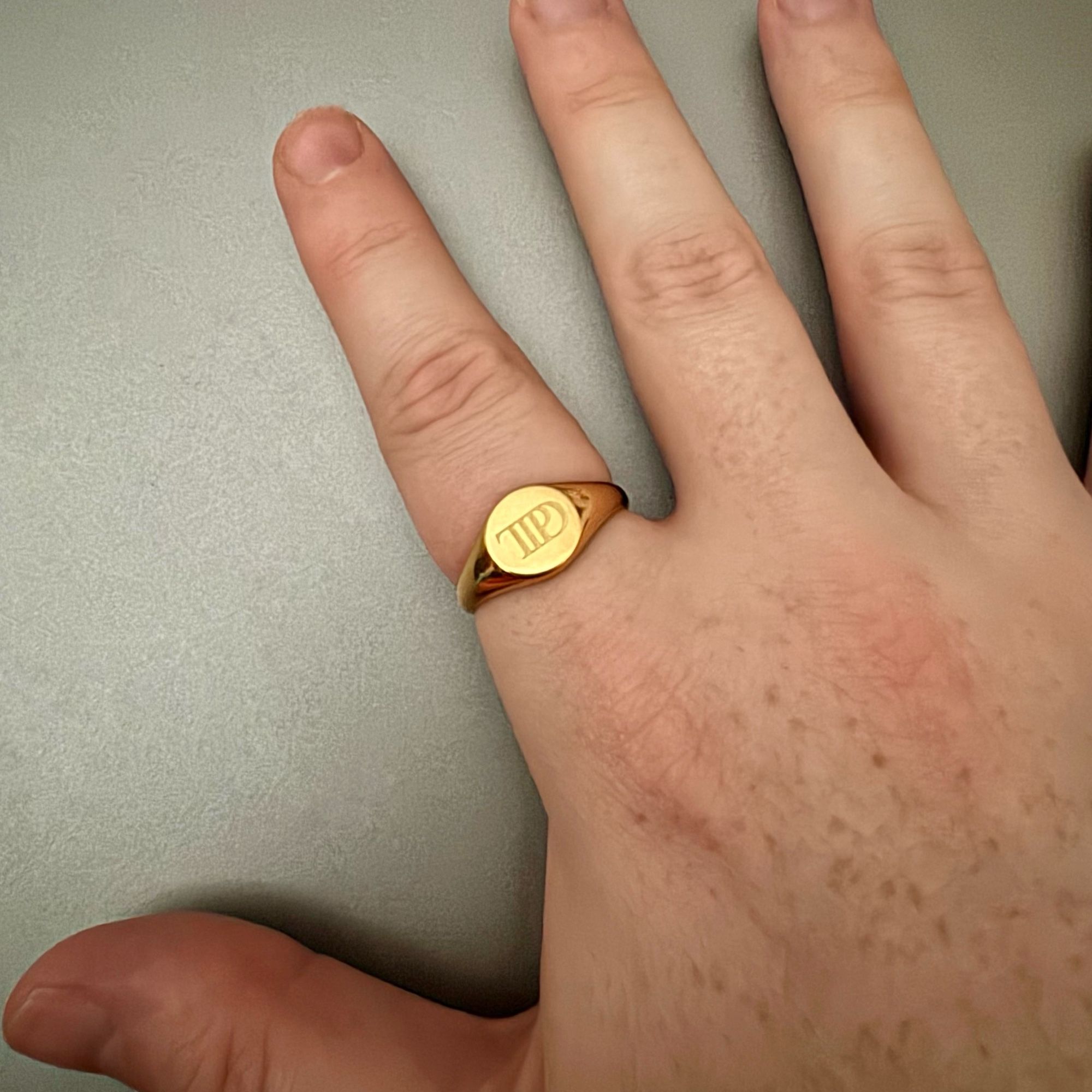 Gold ring on my index finger etched with the TTPD logo