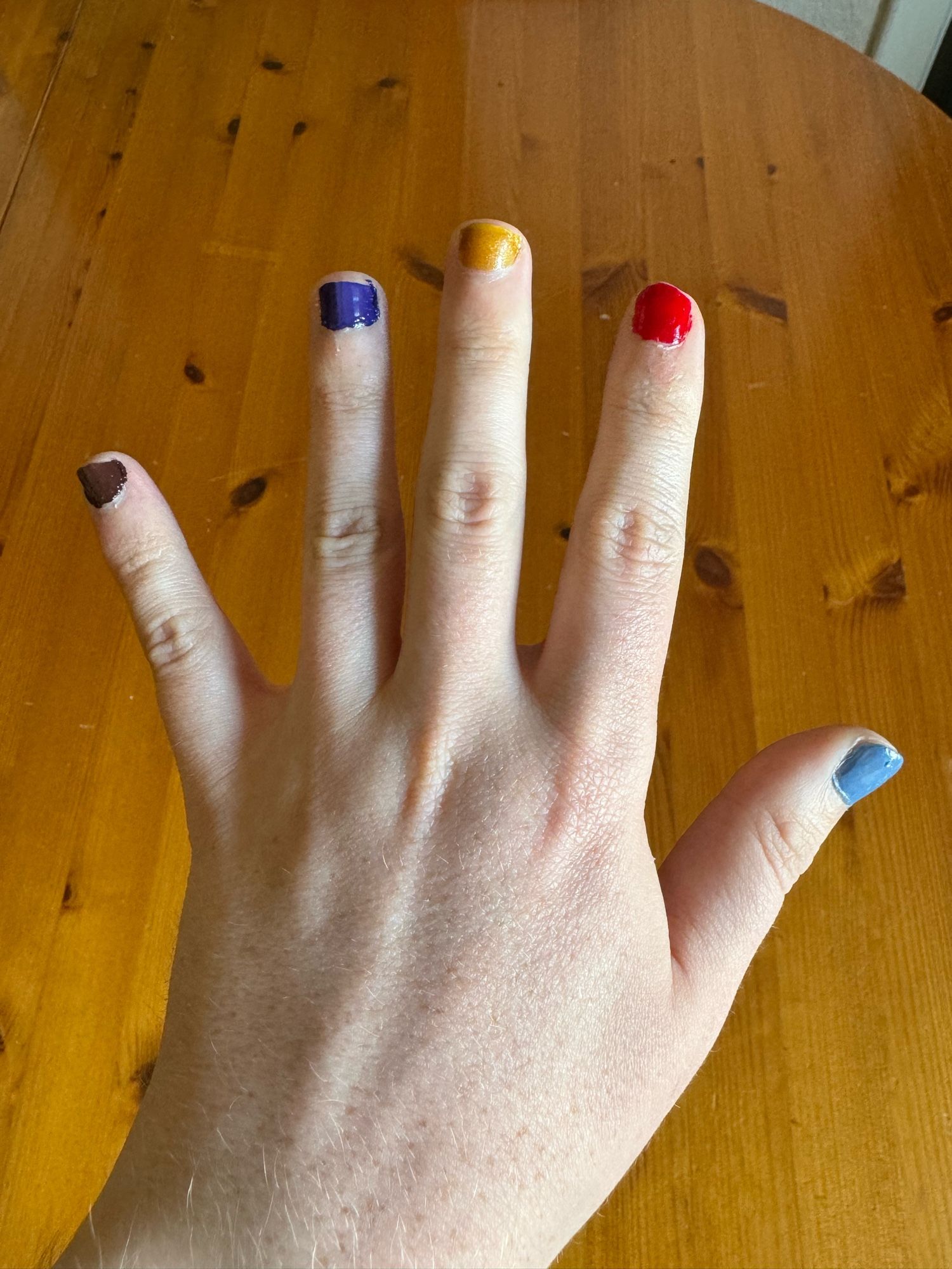 My left hand showing brown, purple, gold, red & light blue nails