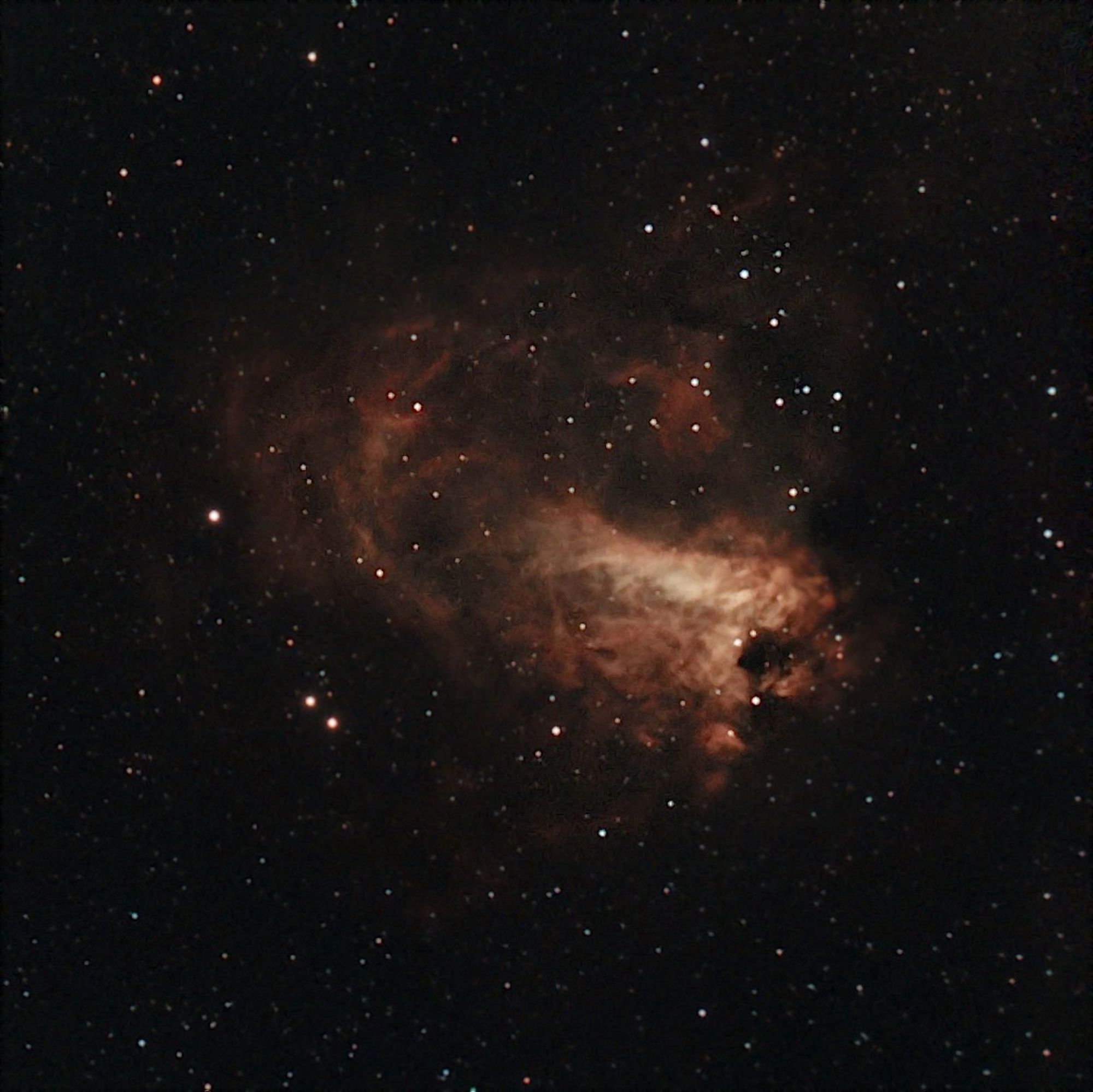 Image of the Omega Nebula, the nebula is a orange-red surrounded by stars