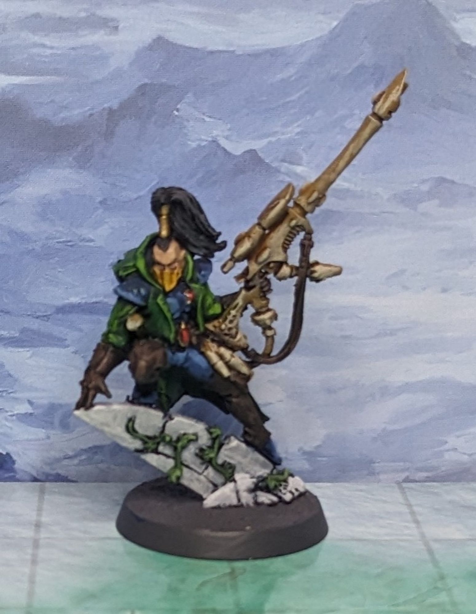 An Aeldari Ranger crouching on a ruin with a long rifle and high ponytail