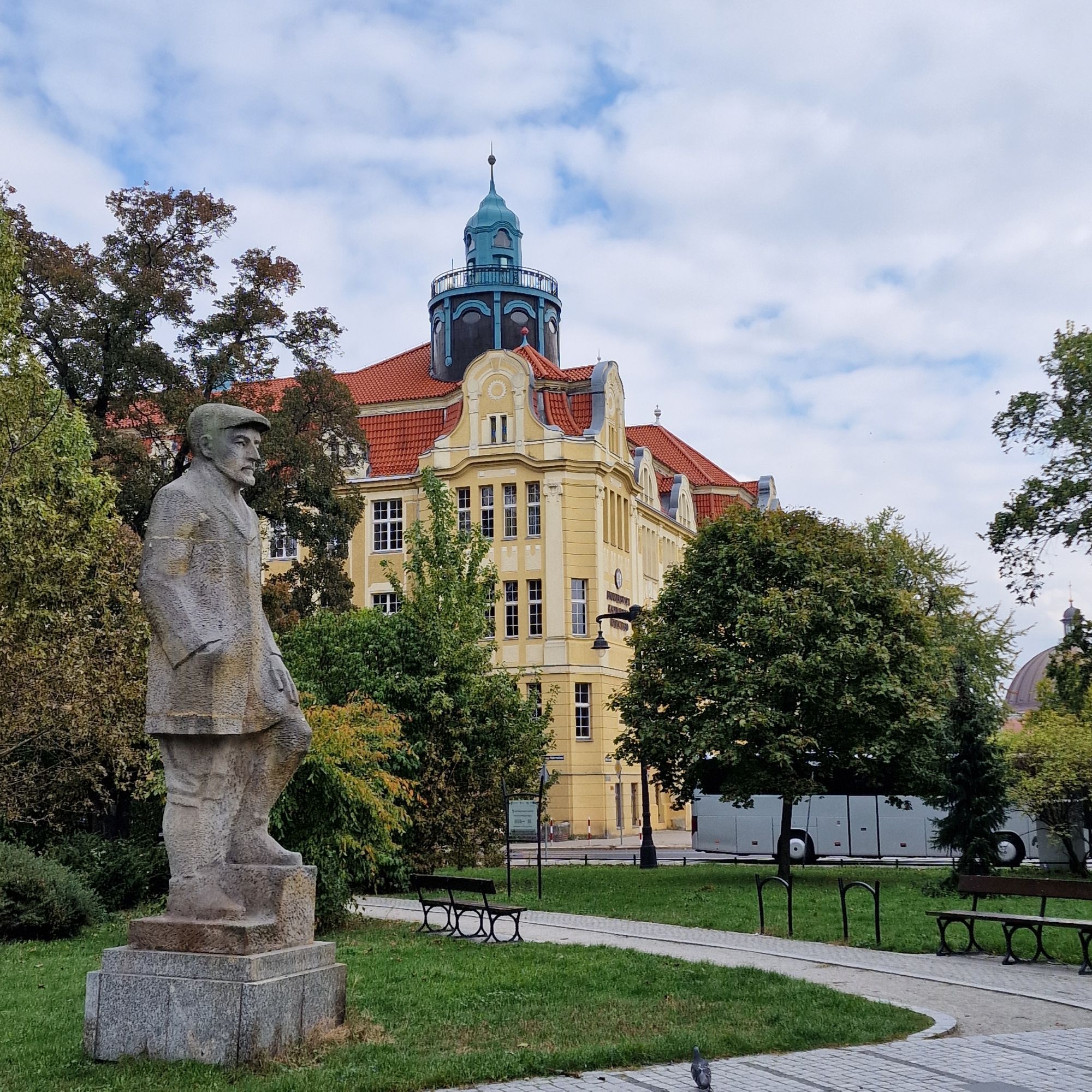 Im Park neben der Philharmonie Begegnungen mit Komponisten aus Polen und der Welt als Skulpturen, dahinter eine Schule um 1909 mit rundem Aussichtstürmchen