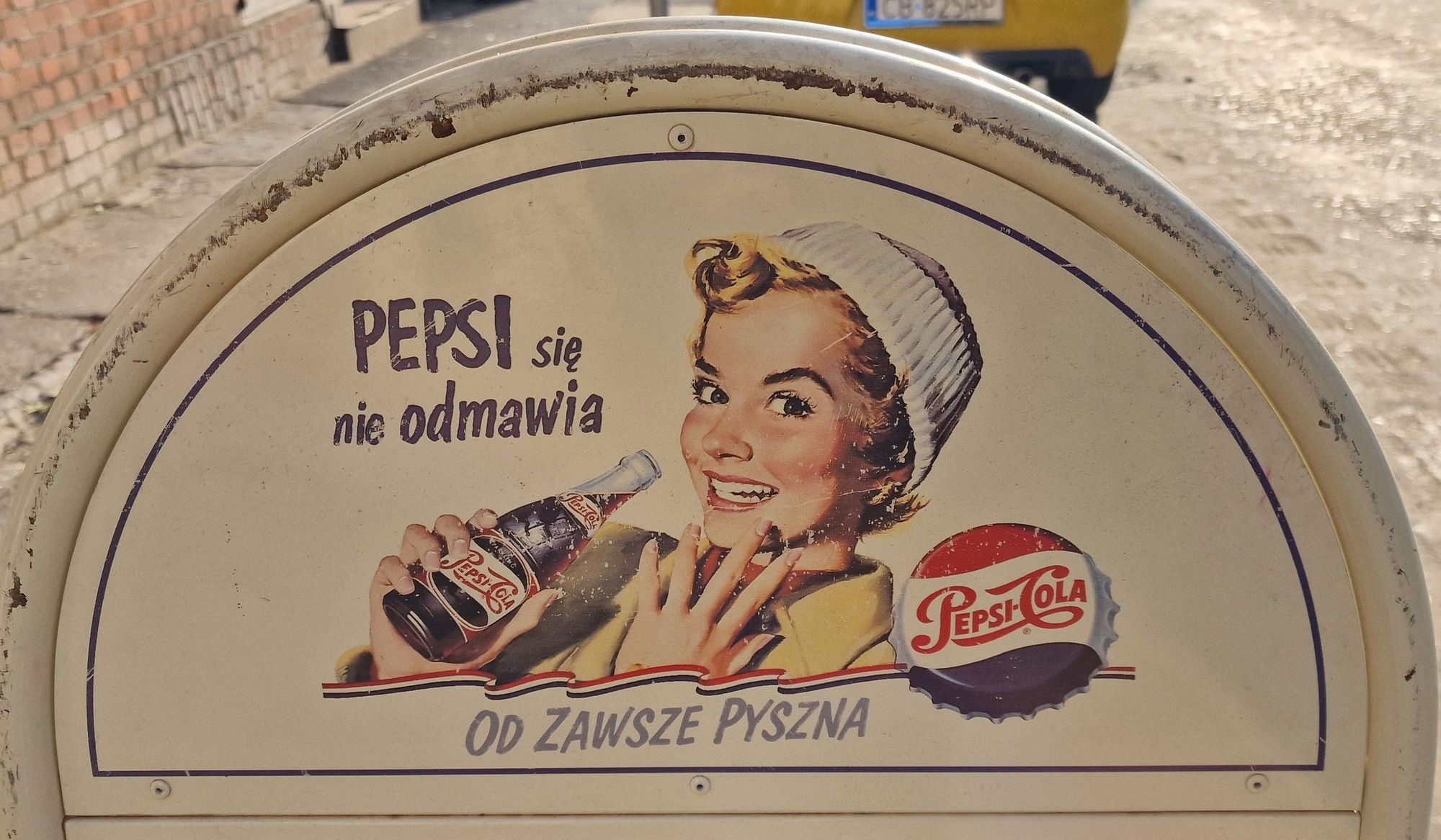 Schild für Essen, im oberen Teil eine alte Werbung für Pepsicola mit einer Figur, im Stiel der 1950 oder 1960 Jahre