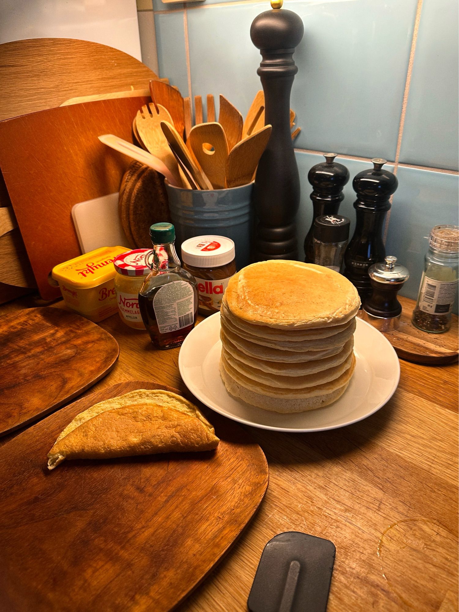 Pancakes stacked on a white plate on a kitchen counter