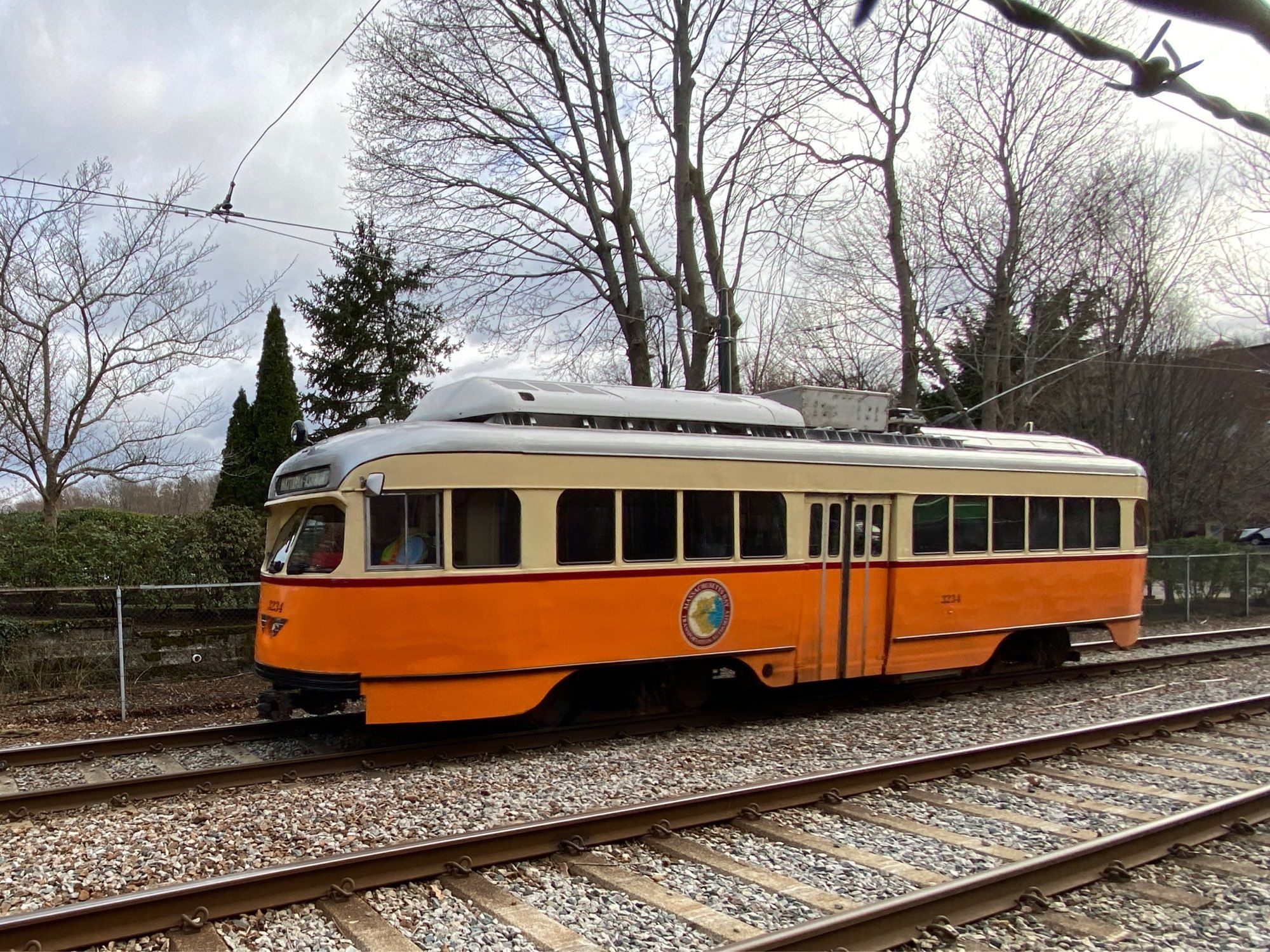 An orange MBTA trolley in Milton headed inbound from Mattapan to Ashmont Station in Boston