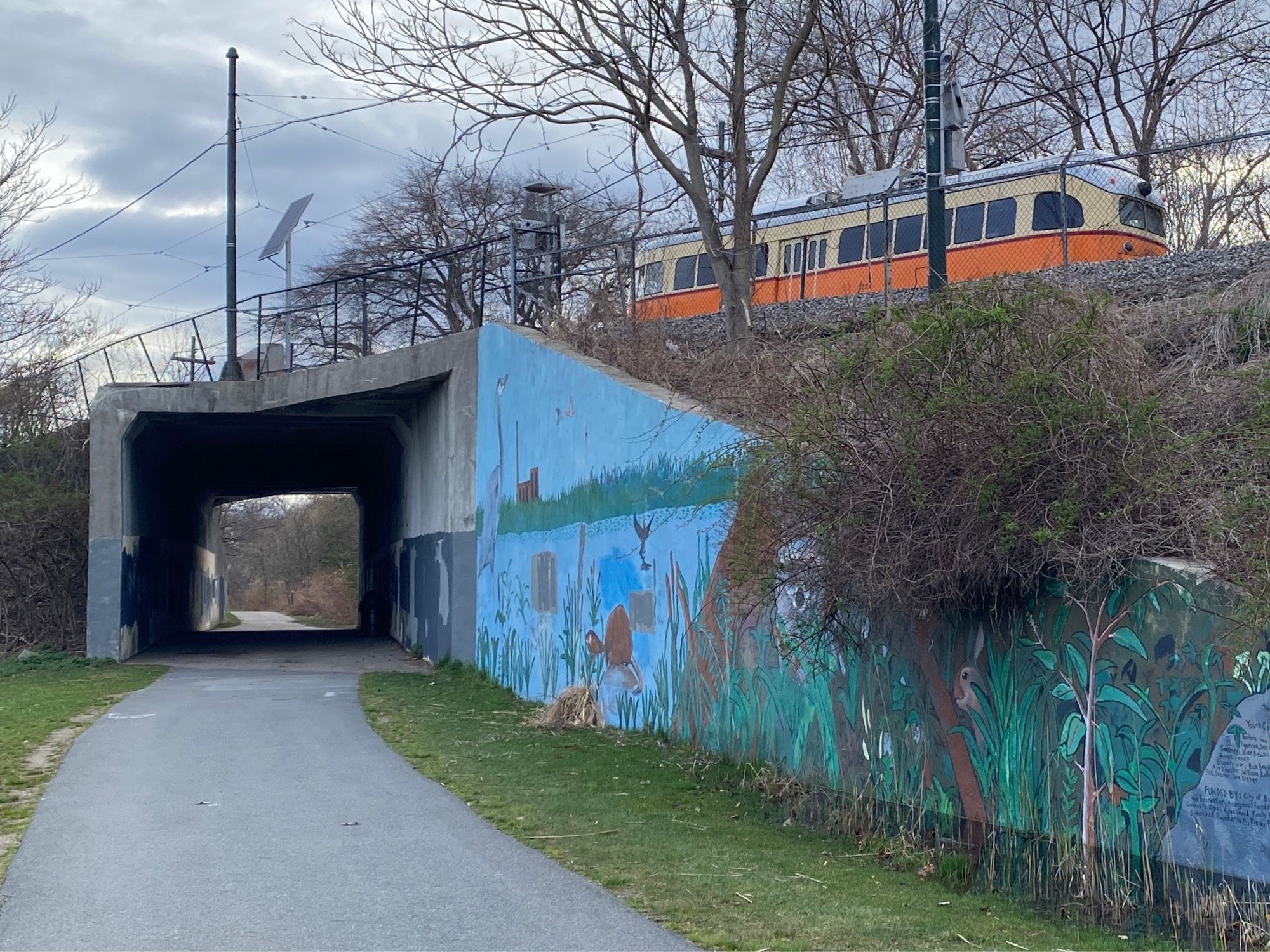 An MBTA trolley headed outbound at the Shawmut Junction overpass above the Neponset River Greenway RailTrail in Boston’s Dorchester neighborhood