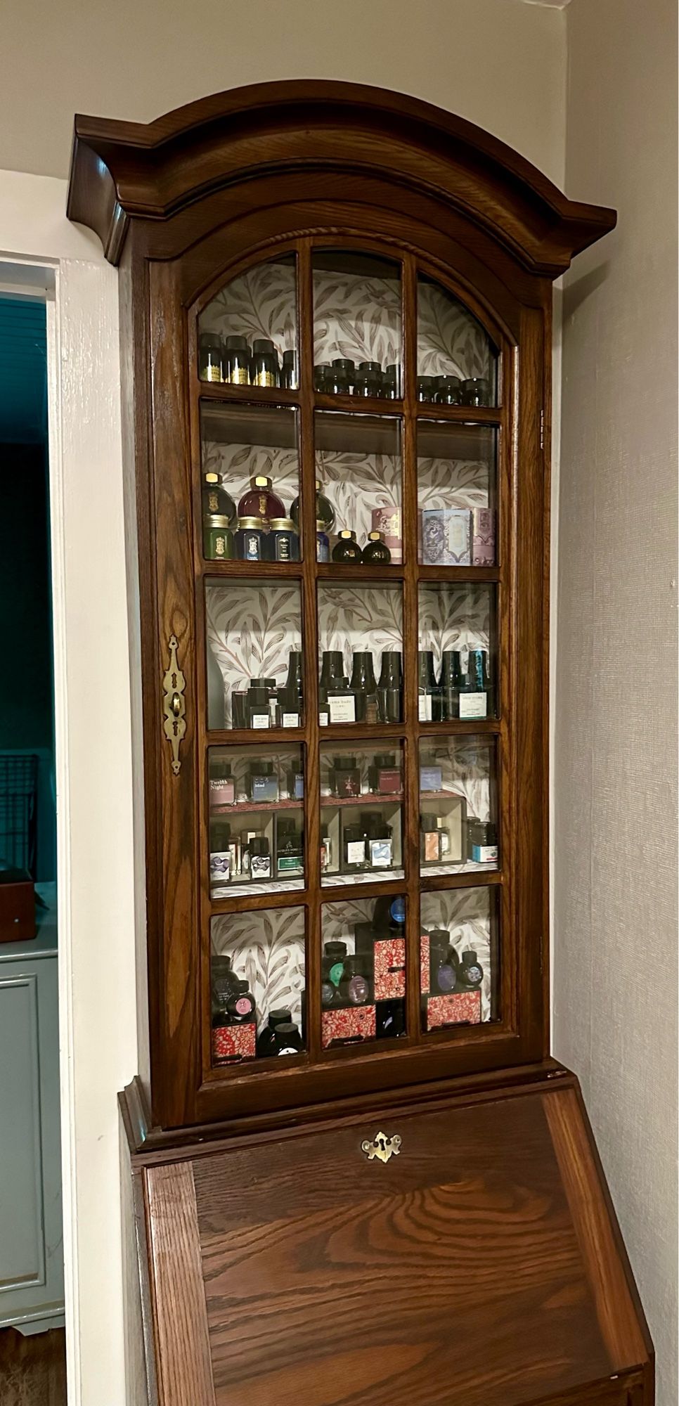 The antique secretary, now full of jars of ink in the glass cabinet