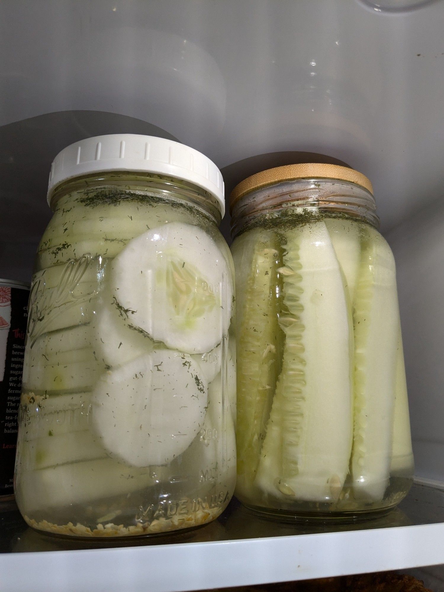 2 pint jars full of pickled cucumbers in the fridge