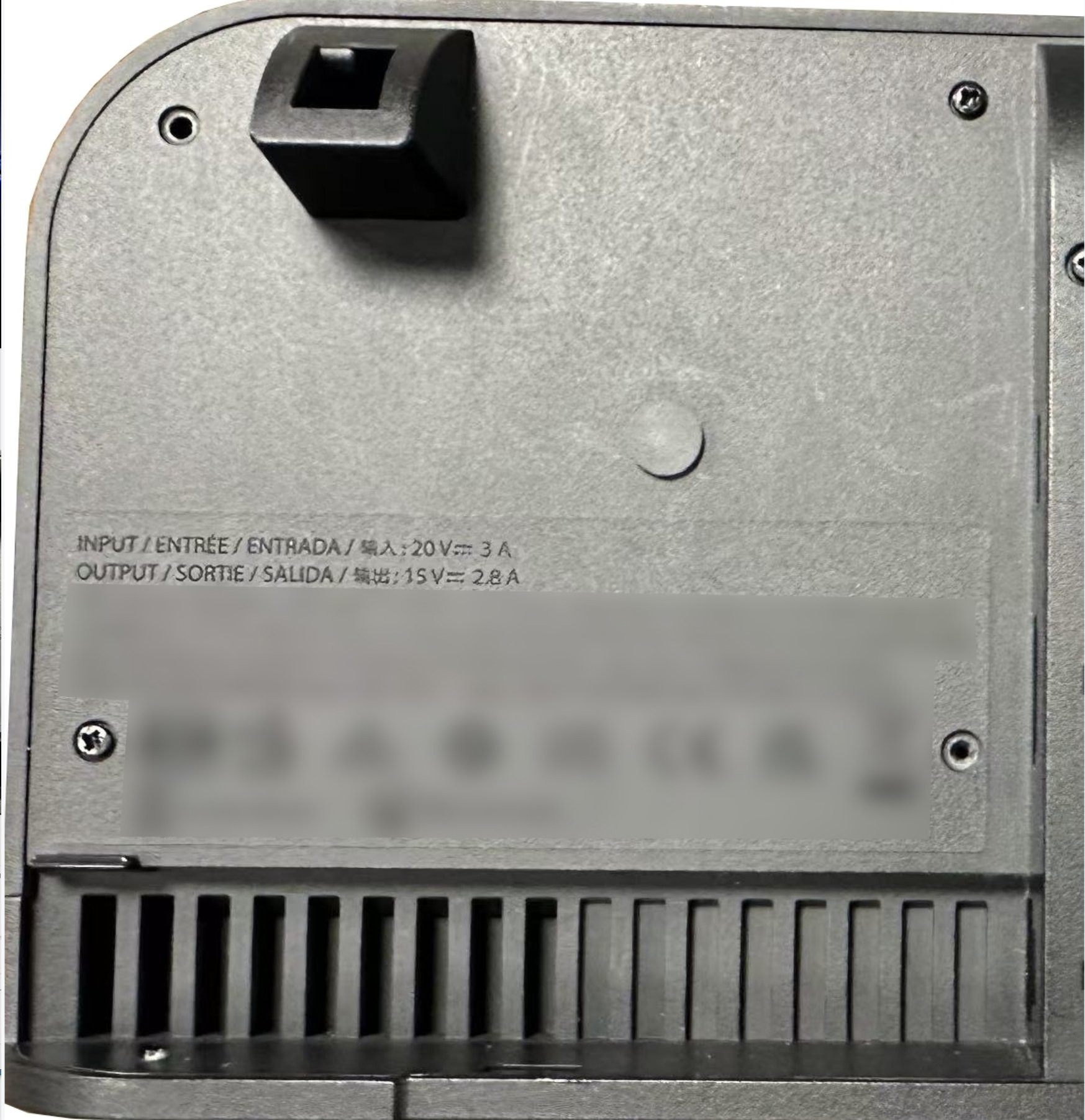 The back of a matte plastic dock, with a fan intake. Visible information states "Input 20v 3A. Output 15V 2.8A".