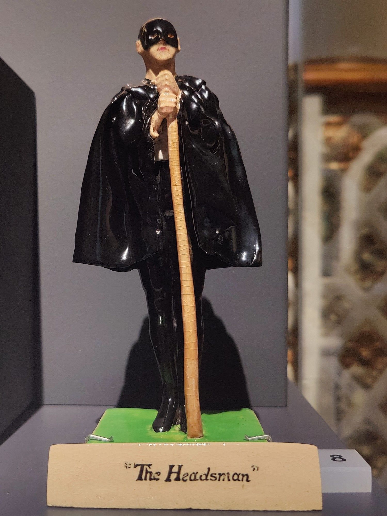 Ceramic figurine of an axe man dressed in black