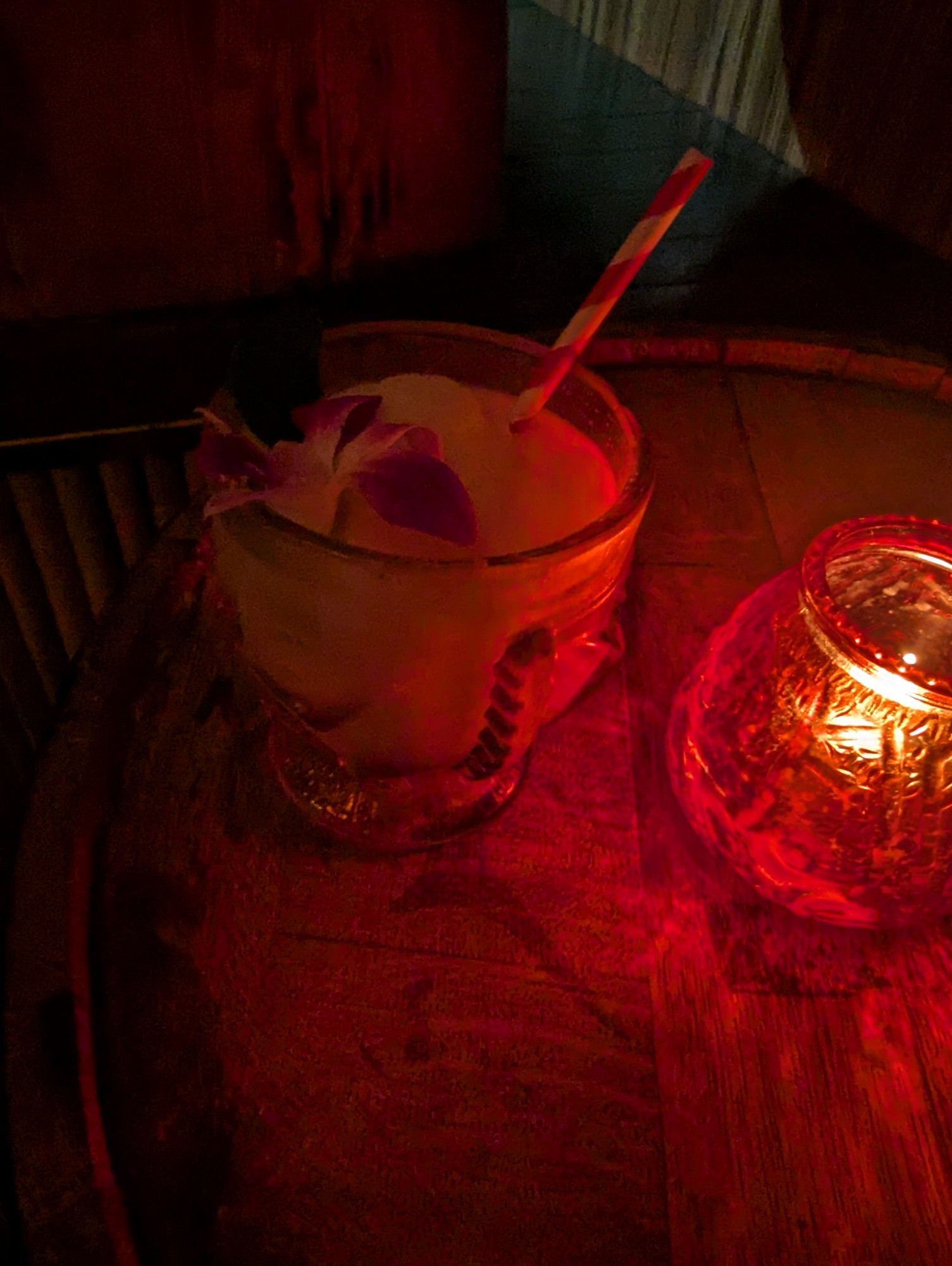 A frozen tiki drink in candlelight.