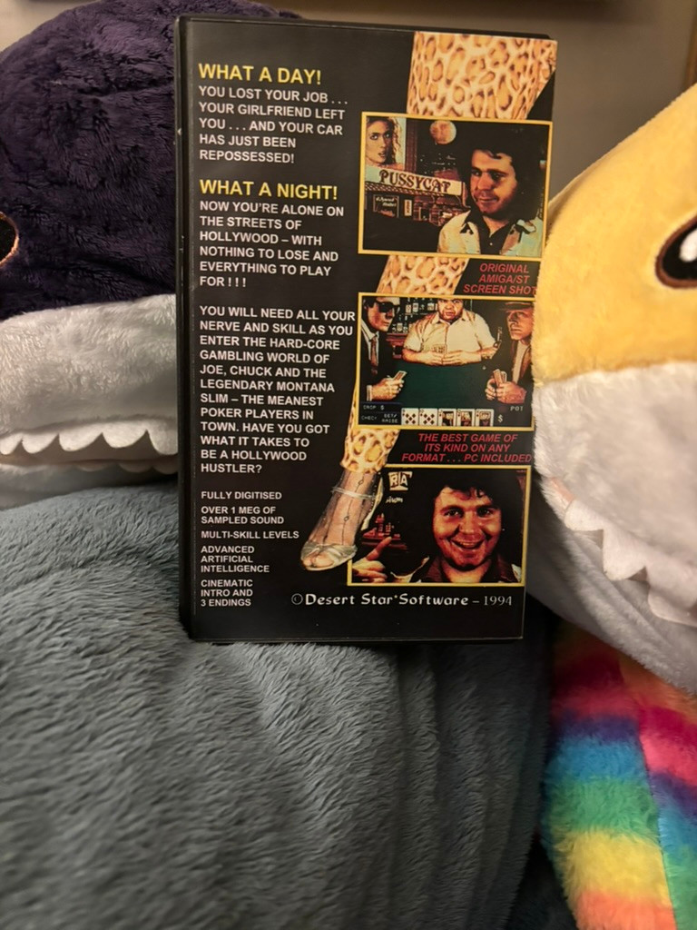 The back cover of Hollywood Hustler on the Atari ST, with a purple shak, a yellow shark, a blue shark and a rainbow shark peering into the frame