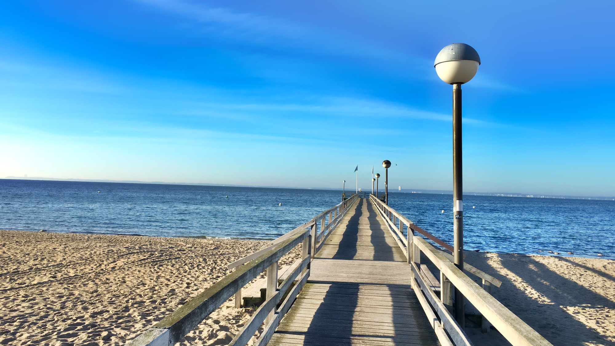 Seebrücke Pelzerhaken Ostsee, links Sandstrand, rechts Seebrücke mit Lampen an der rechten Seite, daneben noch ein wenig Sandstrand und vorn das Meer und der strahlend blaue Horizont

Dieses Bild ist von mir lizenziert unter Creative Commons BY-NC-SA 4.0