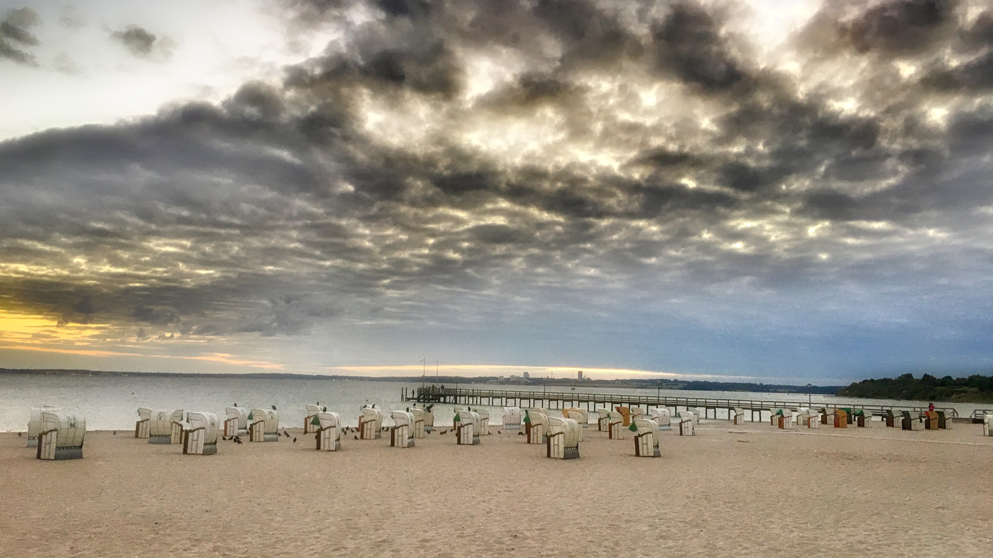 Im Vordergrund der Strand von Pelzerhaken Holstein - dann Strandkörbe, rechts im Bild der Seesteeg und dahinter die Ostsee - der Himmel ist bei aufziehendem Gewitter wolkenverhangen

Dieses Bild ist von mir lizenziert unter Creative Commons BY-NC-SA 4.0