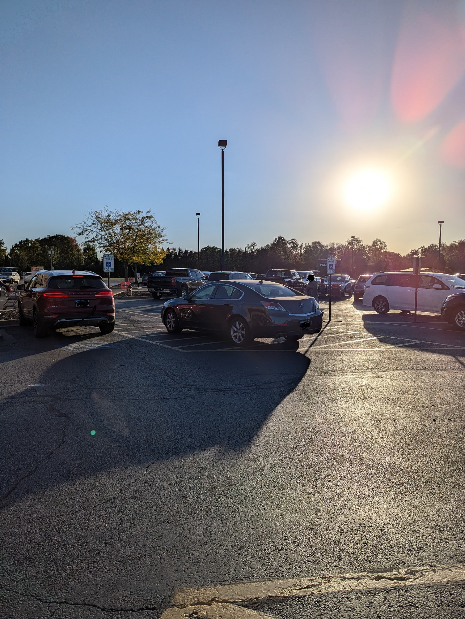 A nice car parked in a handicapped reserved area so handicapped folks can get in and out of their car. 