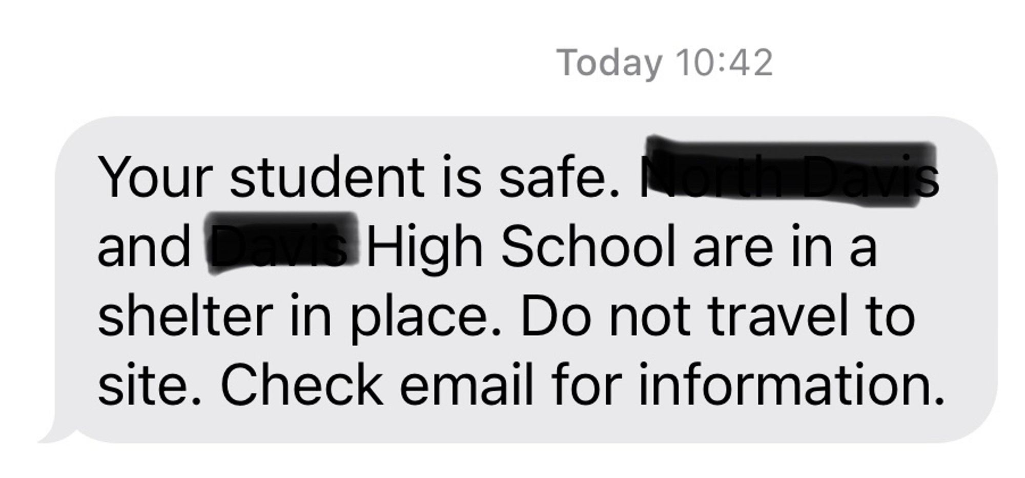 A text that reads: Your student is safe. [School name redacted] and [name redacted] High School are in a shelter in place. Do not travel to site. Check email for information.