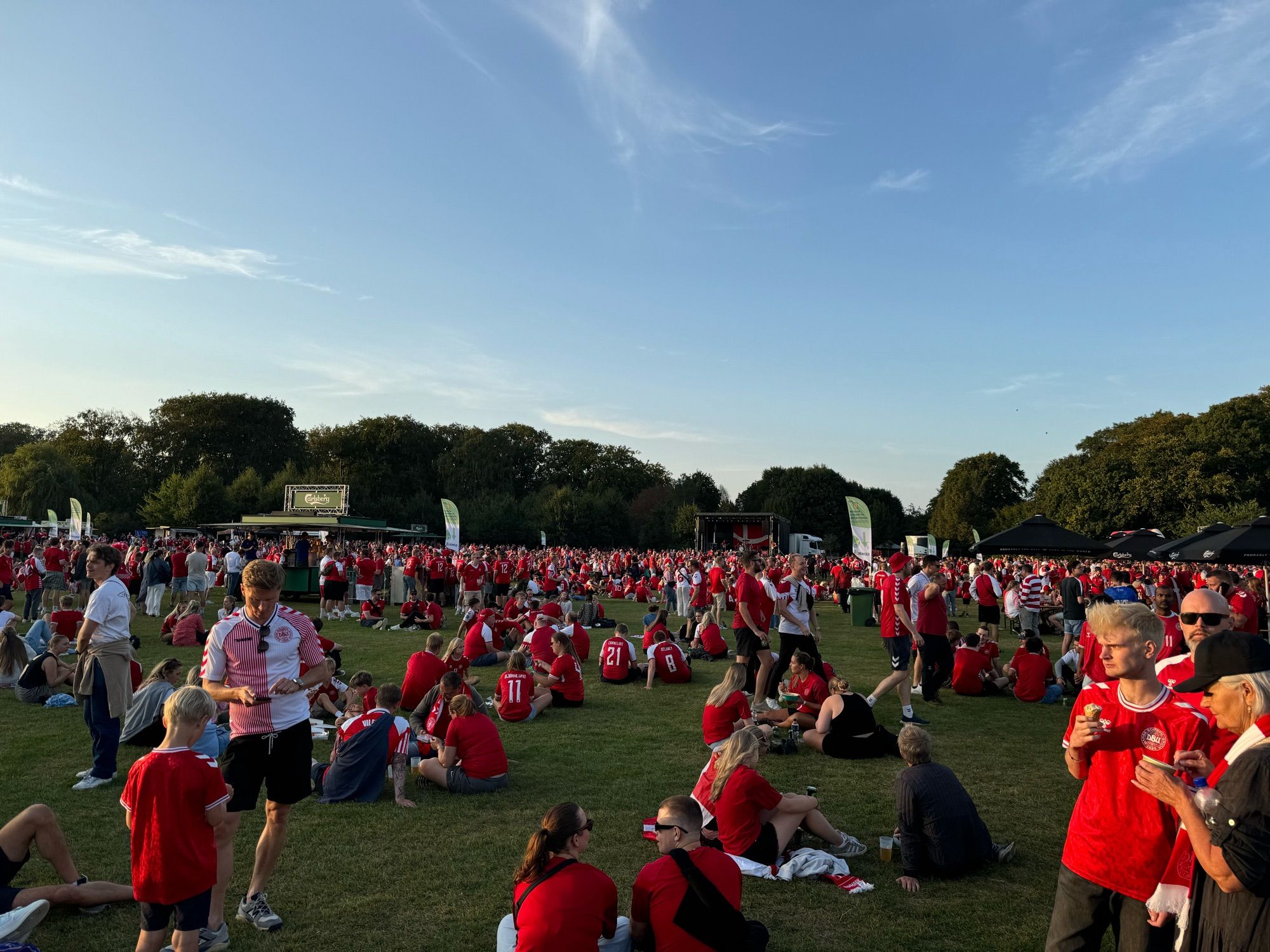 Parkanlage mit dänischen Fussballfans und Konzertbühne mit Band.