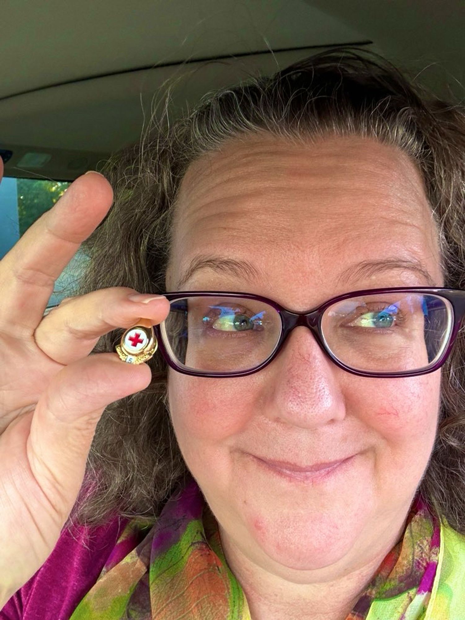 Picture of me holding up a small gold pin shaped like a drop of blood from the Red Cross with the number five on it, signifying that today I donated blood that took me to 5 gallons of lifetime donations. Actually a little bit more than that, but their records only go back to 1999.