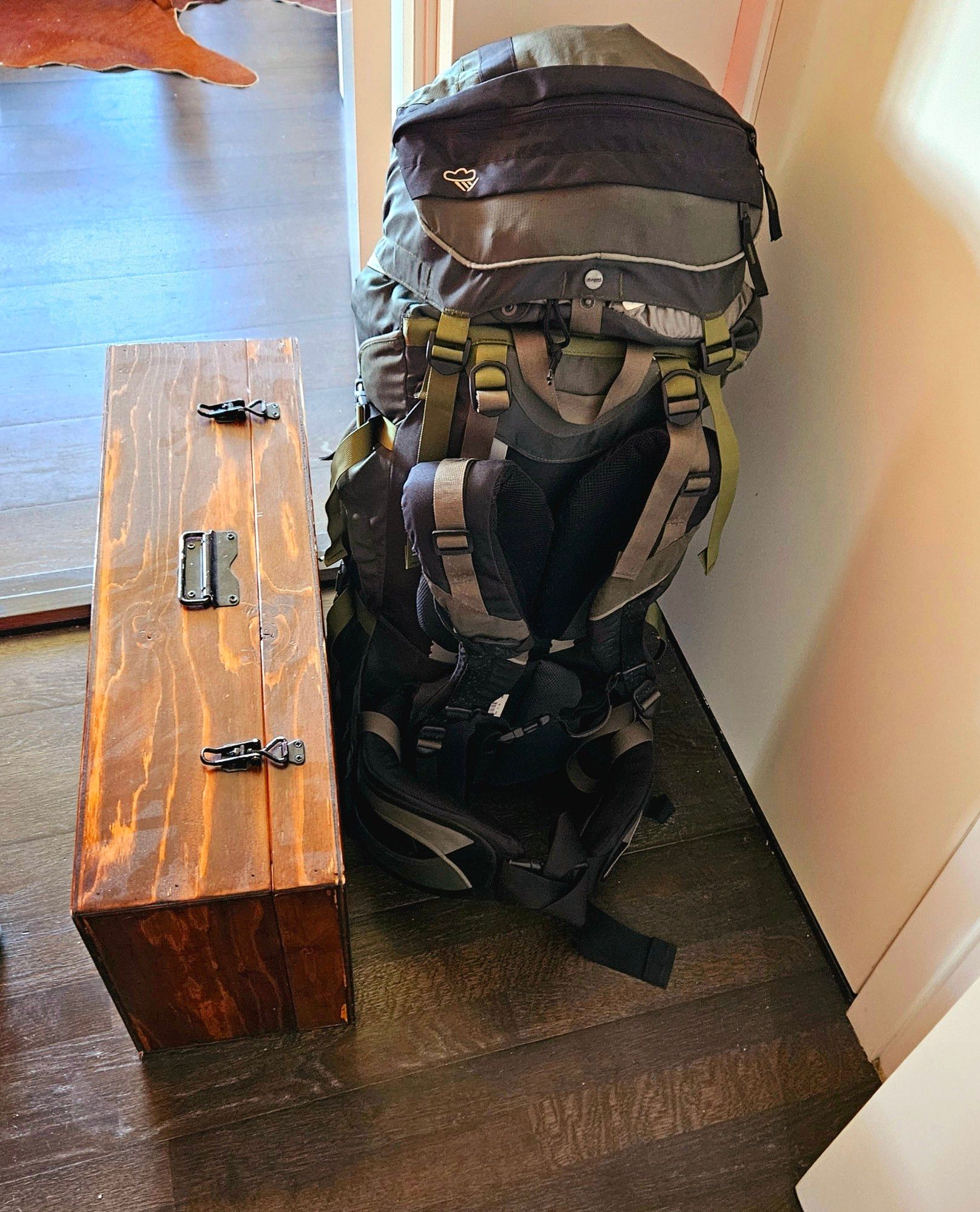 A picture of a hurdy gurdy case along with a large backpack.