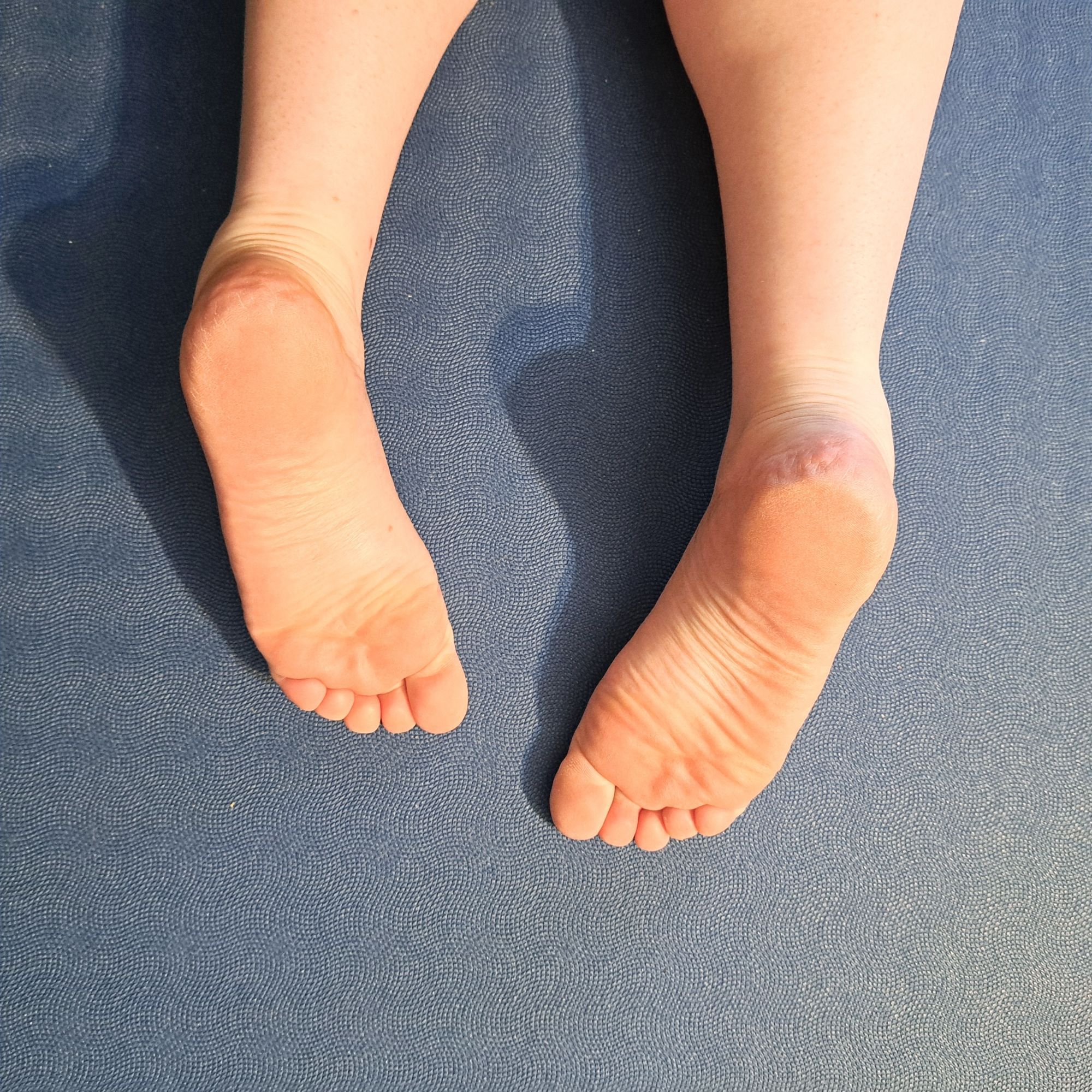 She's lying on her stomach, this is a pic taken from above of the soles of her feet, ankles, and lower legs. Look at those crinkles and cute delicious toes!!