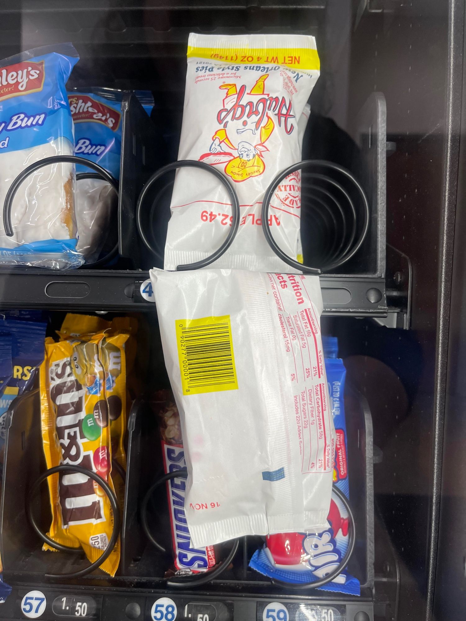 A Hubbies Apple pie hangs stuck in a vending machine