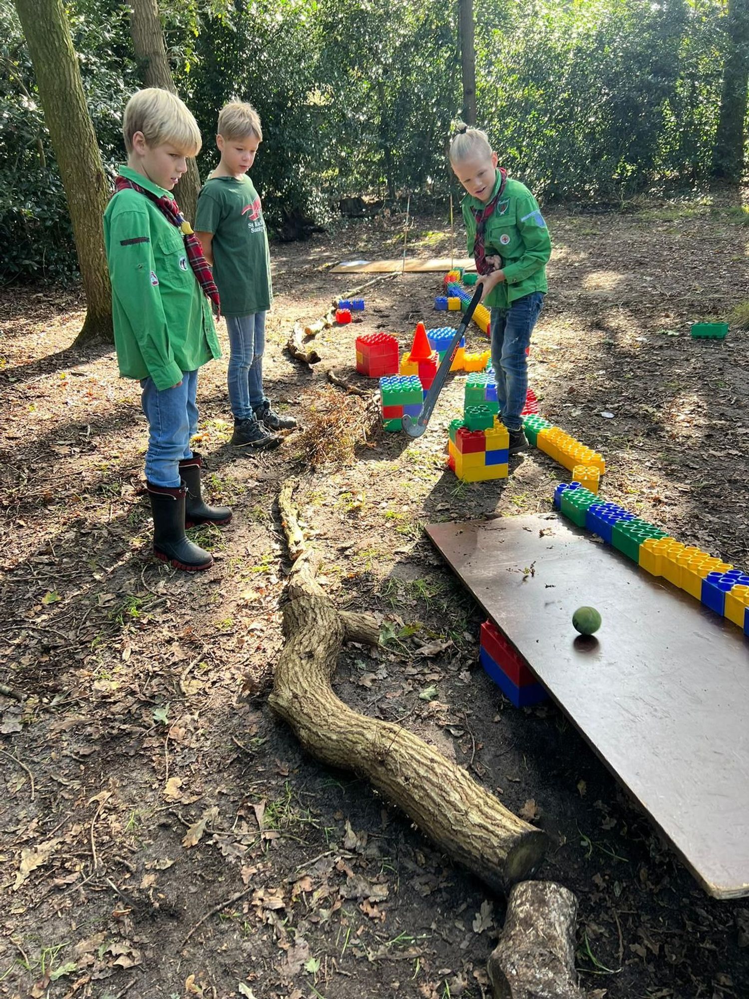 Welpen golfen op hun minigolfbaan in het bos