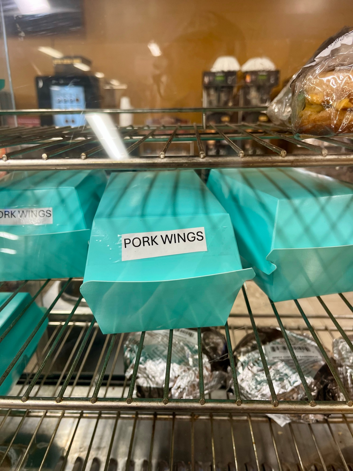 Boxes in the heated sandwich shelves at the truck stop are labelled “pork wings.”