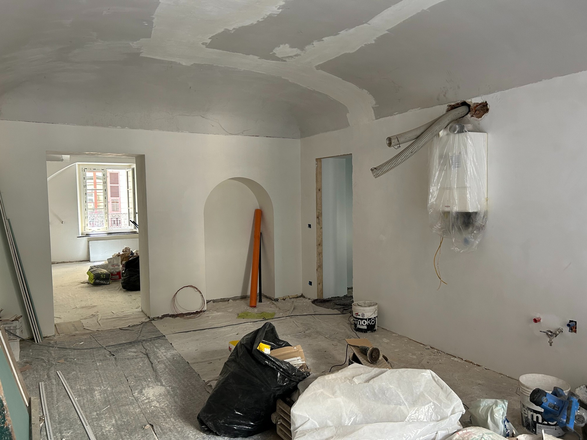 photo of an italian apartment mid-renovation 2023. Trash and construction debris are scattered on the floor