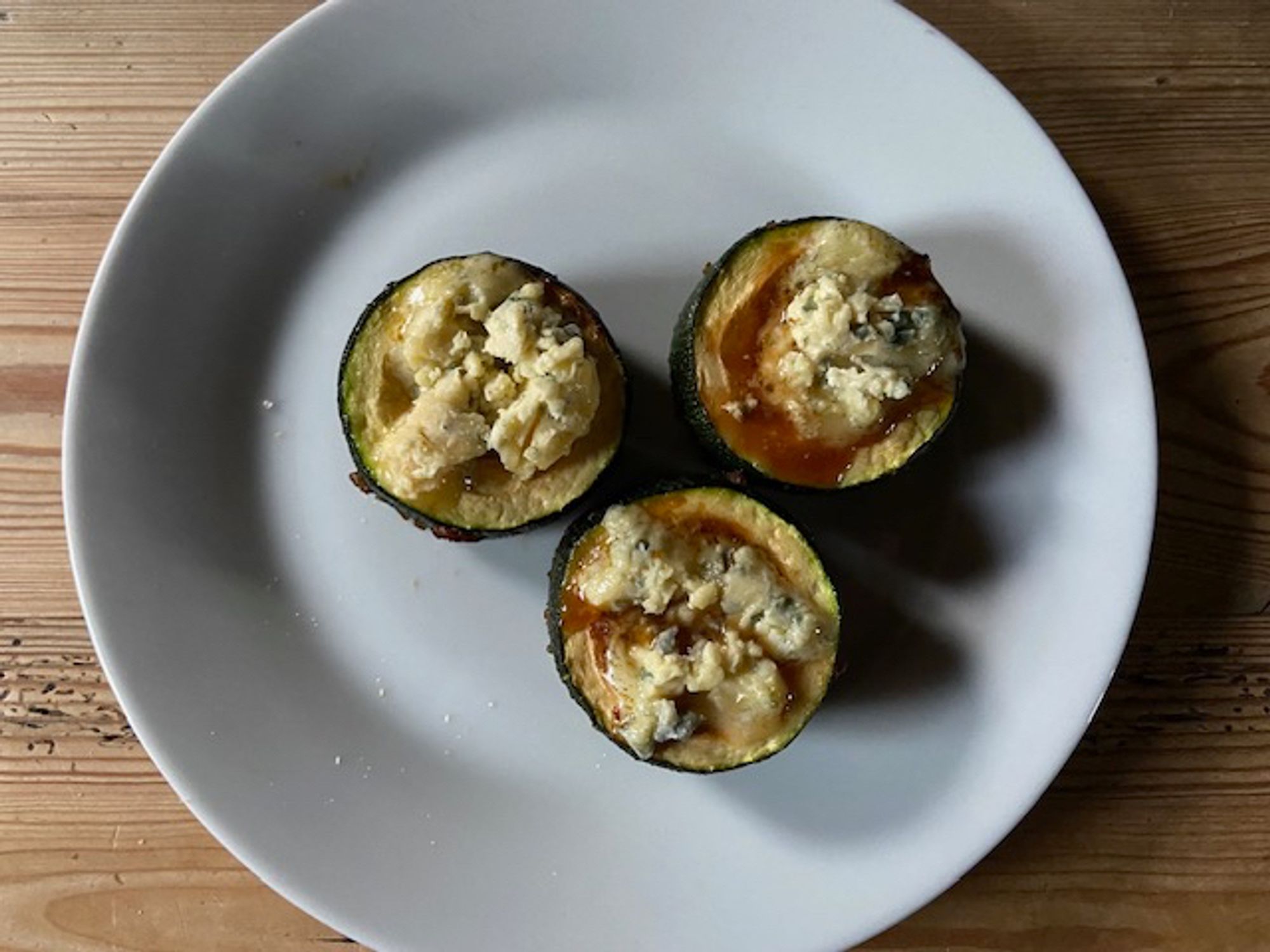 Gemarineerde gebakken courgetterondjes gevuld met blauwe kaas.