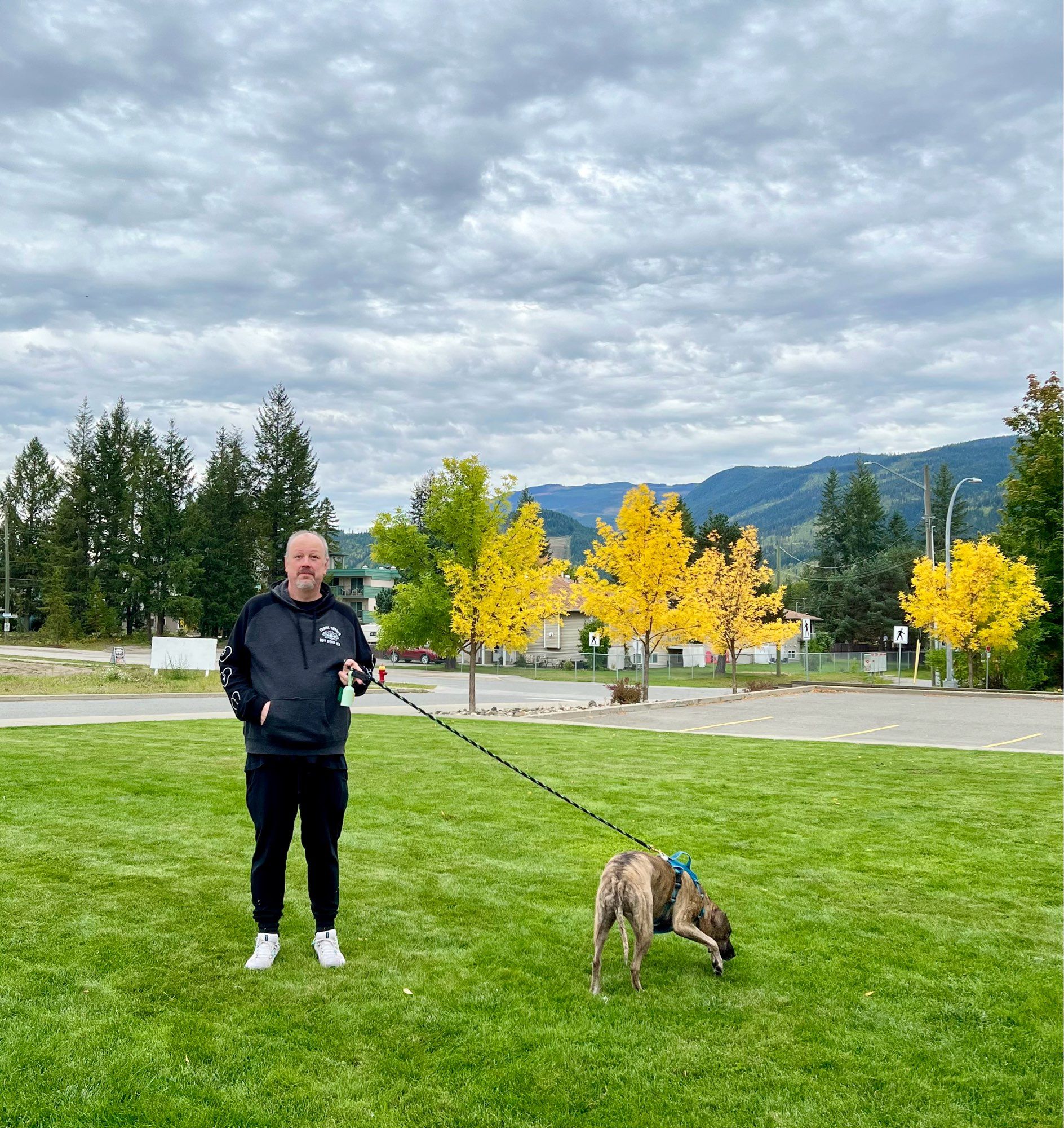 Photo of Jeff and Dolly standing in grass in Clearwater with trees and mountains behind them.