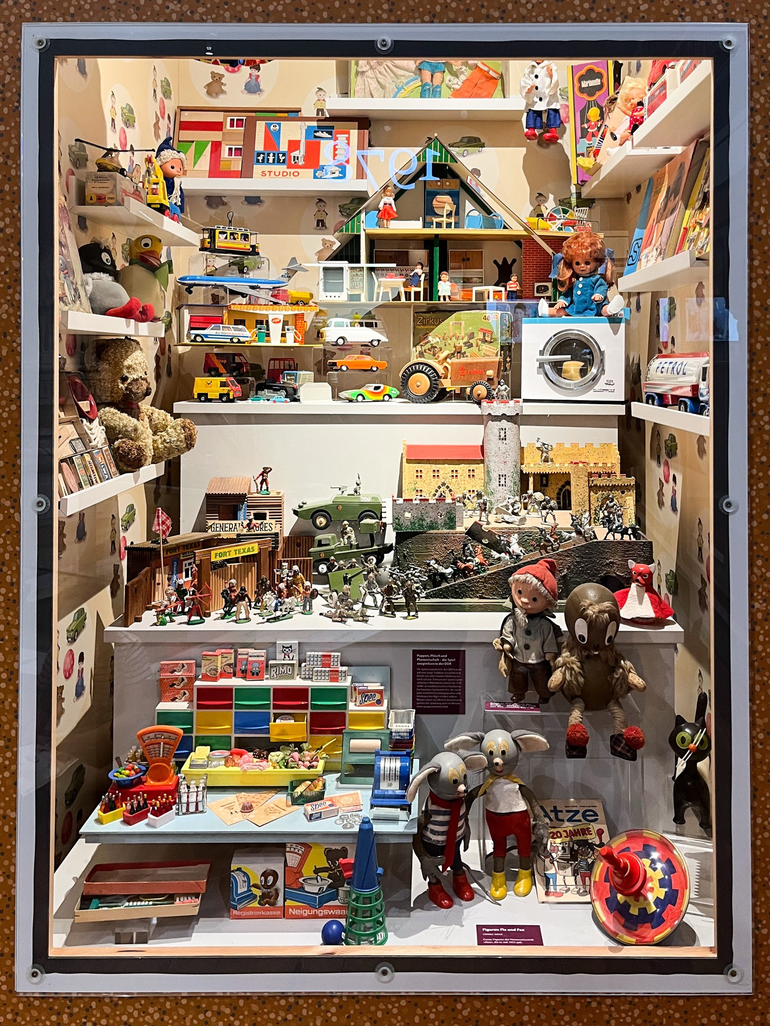 Photo of a museum showcase packed wirh 1970s and 80s toys from East Germany.
