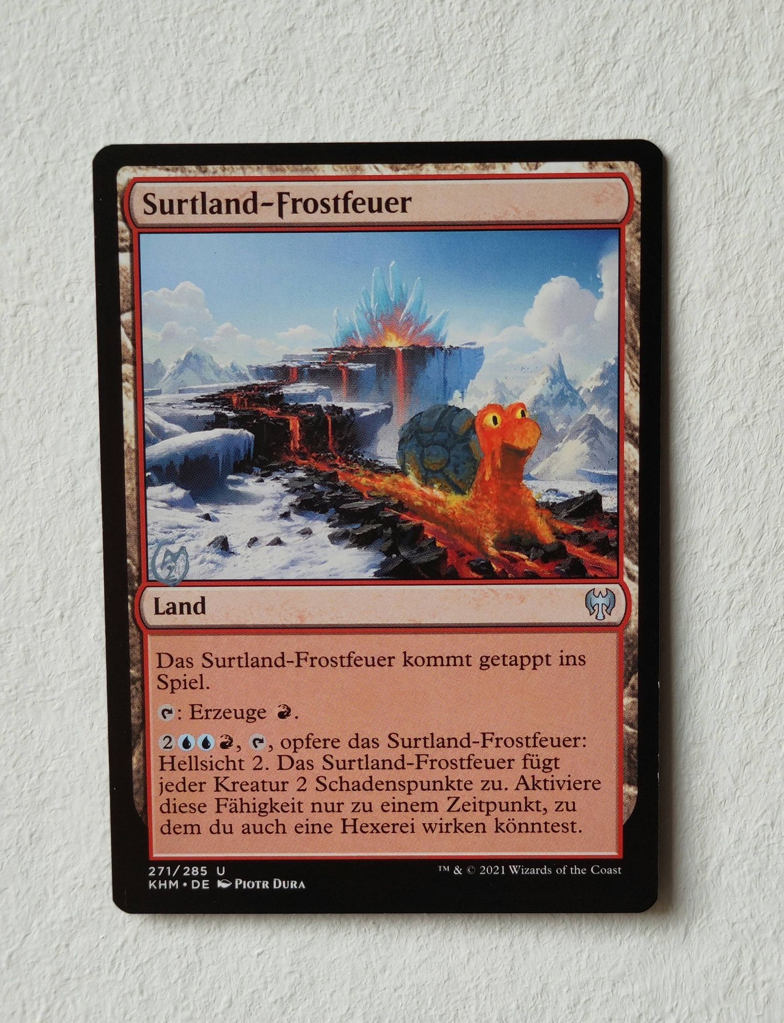 Magic the Gathering card of an ice landscape with a cave in the background that spouts lava. On front on the flowing lava is a Magcargo minding its business.