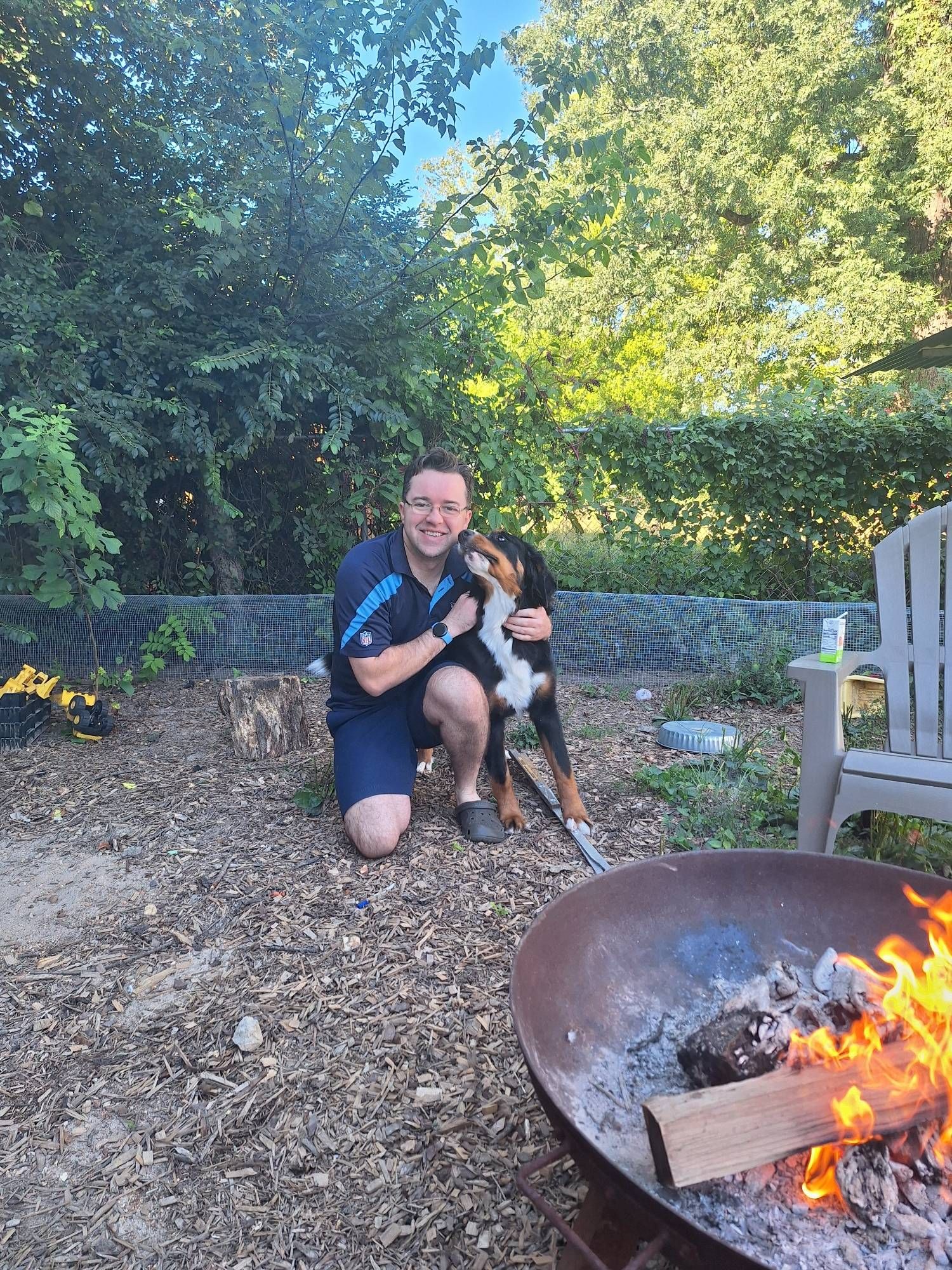 Edie the bernese mountain pup giving kisses around a fire pit.