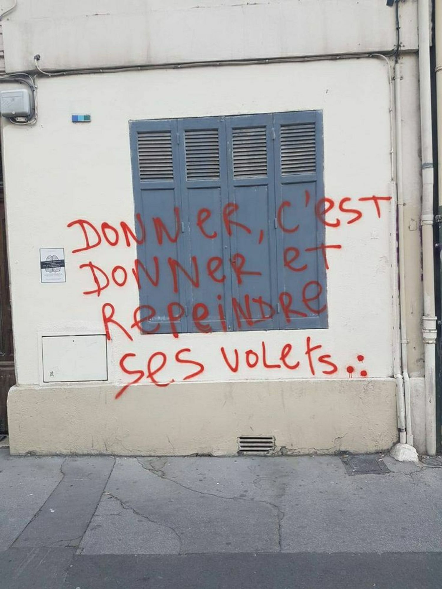 Tag sur le mur d'une maison, et plus précisément sur un volet et sur le mur autour du volet : "donner c'est donner et repeindre ses volets..."