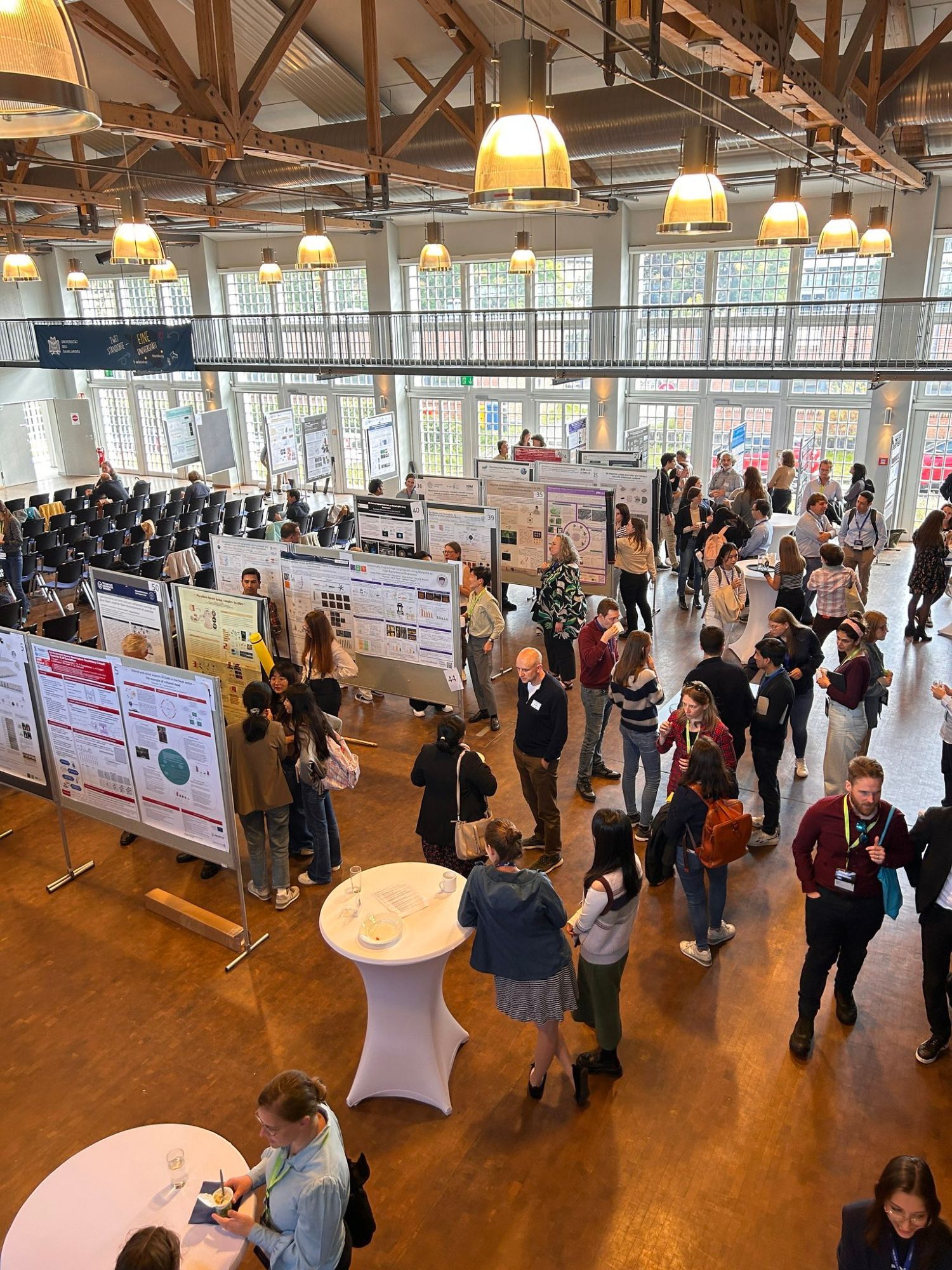 People walking around a poster session at a conference.