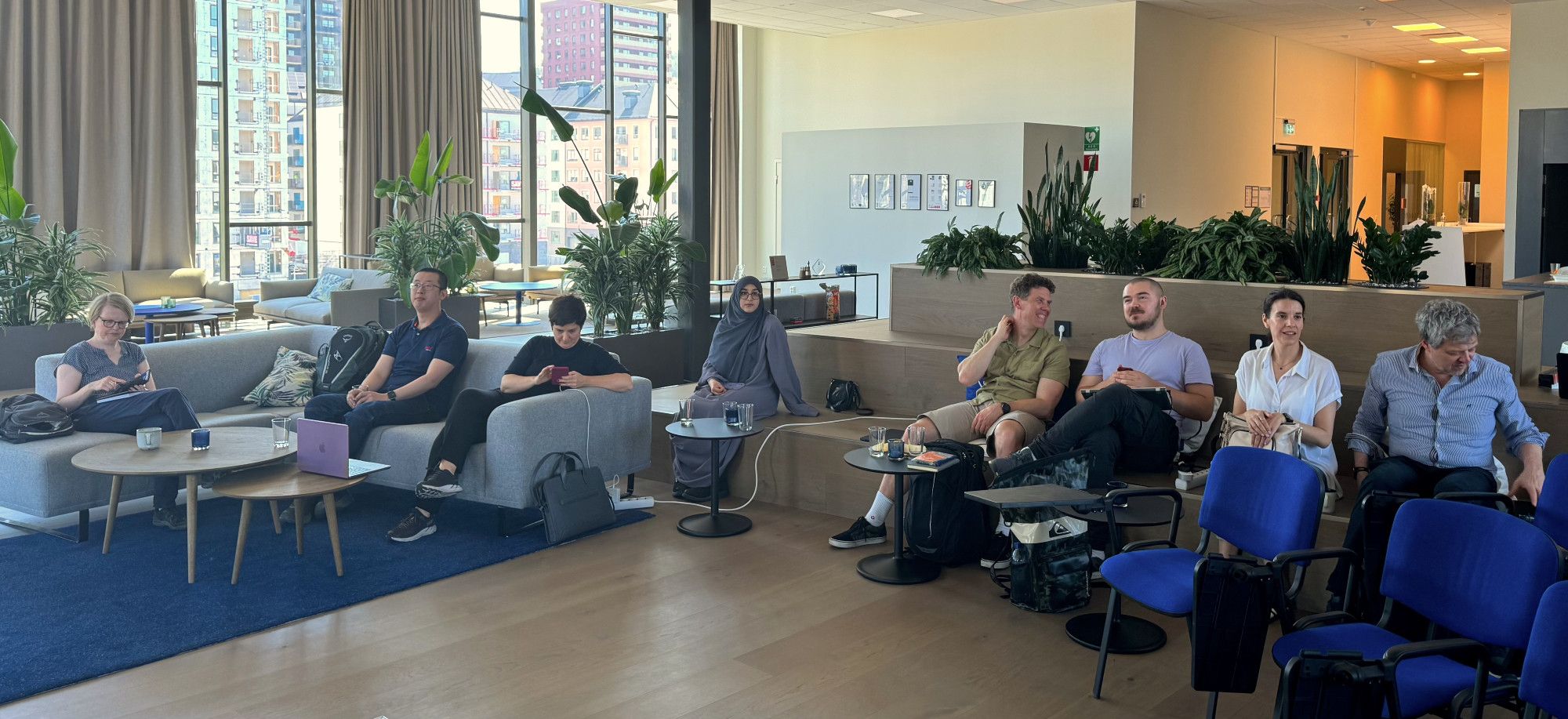 People comfortably sitting in a conference room waiting for a presentation to start.