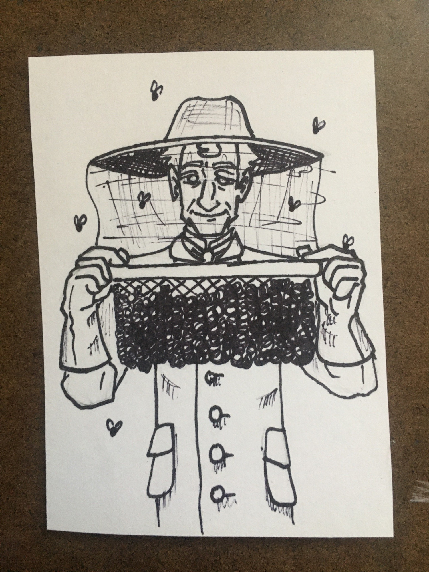 Sholmes is in beekeeping attire and is holding up a honeycomb rack as he inspects the bees.