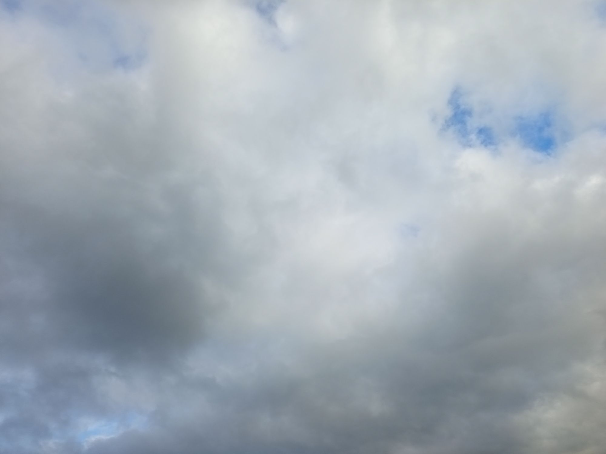 Gros cumulus blancs, légèrement grisés, amassés, qui essaient de recouvrir le ciel en entier. Dans le coin supérieur droit, un petit bout de bleu est visible, et en regardant bien on sent que les nuages s'écartent les uns des autres, laissant apercevoir la couleur du ciel.