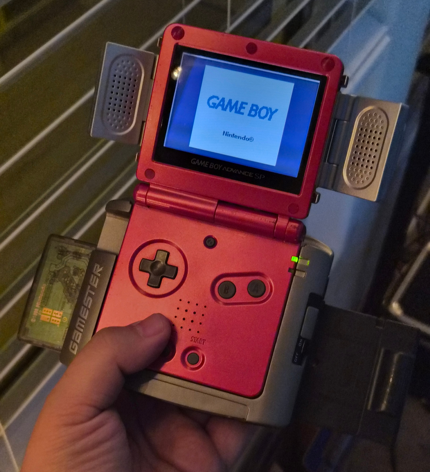 GBA SP in a Radica Game Changer and folding external speakers attachment. There are three cartridges attached to the Radica (Wario Land 3, GB Camera, and Pokémon Pinball). It won't work with multiple GB carts.