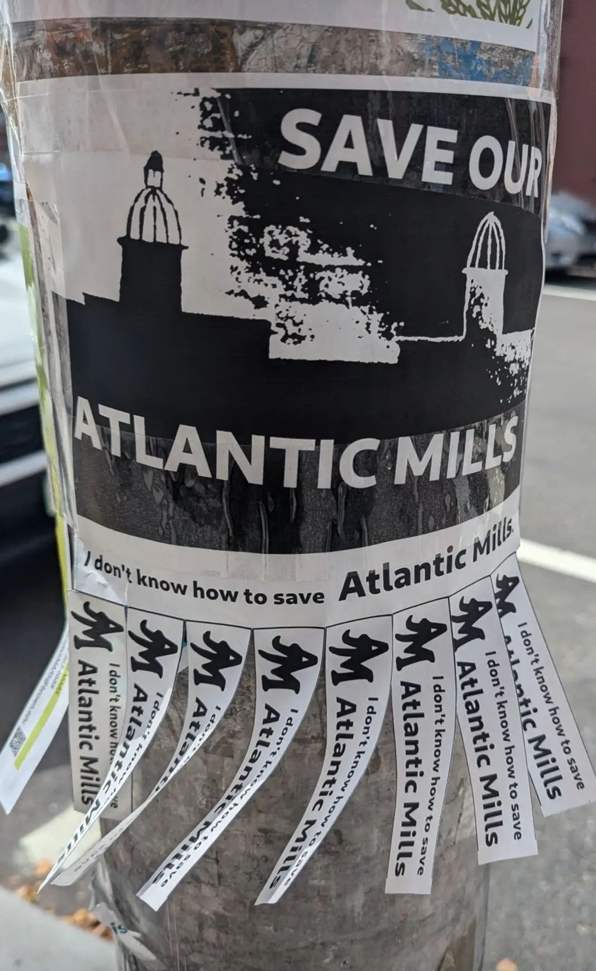 Not my pic, saved a screenshot from Instagram. Flyer taped to a pole: Save our Atlantic Mills. I don't know how to save Atlantic Mills. Tear-off tabs at the bottom all say, "I don't know how to save Atlantic Mills."